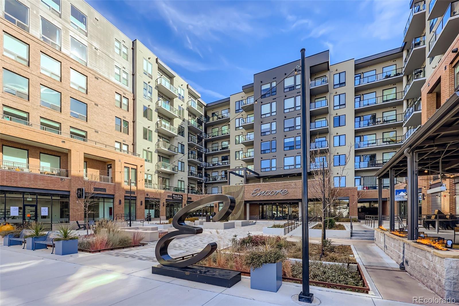 Quick Possession and Easy To Show! Gorgeous end unit with only one neighbor features a living room, kitchen, dining, 2 bedrooms, 2 baths, laundry and private covered balcony with spectacular views. Meticulously maintained - pride of ownership shines throughout. $25,000 in upgrades and improvements including a renovated second bathroom with extra large soaker tub, new tile surround, Euro glass, new fixtures, new lighting;  additional lighting in unit including RH chandelier in living room, overhead lighting in both bedrooms; custom closets throughout; extra cabinets/shelving in laundry room; $4,000 KitchenAid refrigerator; Culligan water system; new bedroom carpeting;  custom automated window coverings and more.  Relax on the extra large covered, very private patio that showcases gorgeous mountain views.  The storage unit (S-303) and two garage spaces (R-57 and R-58) are mere steps away from the unit.  This is a highly sought-after unit in the very quiet, highly desirable Encore building. Located in the heart of downtown Castle Rock where restaurants, shopping and salons are right at your fingertips. In addition, there are countless outdoor activities such as hiking and biking but also beautiful concert venues and the Castle rock incline just to name a few. Building amenities include a state-of-the art fitness center, dog wash, dog park and golf/soccer simulator room. What more could you ask for? Other for sale units here are interior facing with no view and smaller balconies with no privacy. Don't miss your opportunity. Welcome home!!!! This home also available for rent / lease @$3300/mo.