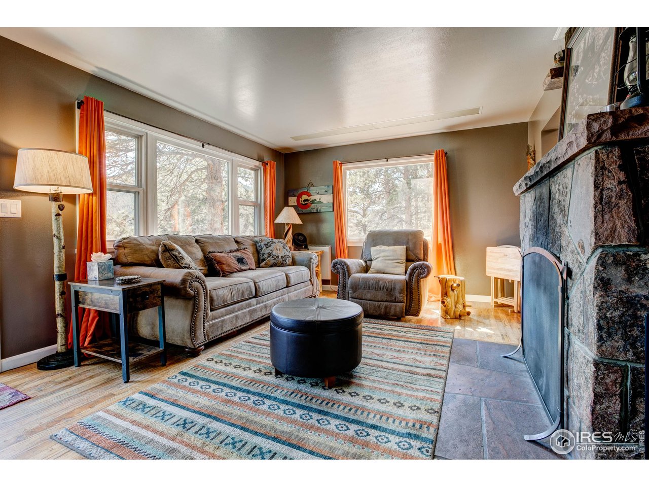 Escape to the mountains, and let your investment work while you're away. Welcome to this fully renovated and fully furnished log cabin tucked into a quiet, level .6-acre lot surrounded by Ponderosa pines. This is mountain living done right, relaxed, rentable, and ready! This is the kind of Estes Park property buyers dream about: peaceful, private, and already performing as a successful short-term rental. Everything is in place to start generating income immediately, or to simply arrive with your suitcase and unplug. Furniture, decor, kitchenware, and linens are all included, making this a truly turnkey opportunity. Inside, the cabin lives larger than its footprint. The bright, open living space is filled with natural light and centered around a striking stone wood-burning fireplace, creating a cozy mountain ambiance guests love. The fully remodeled kitchen (2021) features expanded space, new cabinetry, stainless steel appliances, a gas range, granite countertops, and plenty of room to cook, gather, and entertain. The thoughtfully designed 1 bedroom, 1 bath layout offers comfort and function for weekend escapes, year-round living, or short-term guests seeking an authentic mountain experience. Hardwood floors, fresh paint, updated lighting, and upgraded electrical and plumbing provide peace of mind and modern comfort. Step outside to the east-facing deck, perfect for morning coffee, evening stargazing, and watching elk and deer wander through the nearby meadow. A partially fenced yard and large detached storage shed offer space for bikes, skis, and all your recreational gear. Located just minutes from downtown EP and a short drive to RMNP, this cabin delivers the lifestyle visitors crave, and the convenience owners appreciate. Whether you're looking for a proven income-producing STR, a personal mountain retreat, or a low-maintenance full-time home, 930 Highacres offers rare simplicity, charm, and opportunity in one unforgettable package.