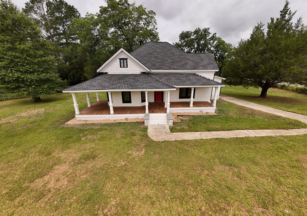 Everything old is new again!  Perched on a picturesque hilltop just seven miles from Thomasville, this beautifully restored 1917 farmhouse blends timeless character with modern convenience. Situated on a desirable corner lot, the property welcomes you with a large wraparound front porch—the perfect place to enjoy morning coffee, evening sunsets, and the peaceful country setting. The home has been completely renovated throughout and features an open-concept floor plan designed for comfortable everyday living and entertaining. Recent improvements include a new roof, HVAC system, windows, doors, lighting fixtures, and spray foam insulation for outstanding energy efficiency. The stunning kitchen serves as the heart of the home, showcasing custom cabinetry, a handcrafted island, tile backsplash, custom concrete countertops, and a full suite of stainless-steel appliances,  and even includes a washer and dryer. Rich pine flooring flows throughout the main living areas, while new tile flooring enhances the bathrooms and laundry room. The spacious primary suite offers a private retreat with a beautifully appointed bath featuring a walk-in shower and dedicated vanity area. Outside, you'll find a fenced yard, circular driveway, and a large covered patio ideal for grilling, entertaining friends, or gathering with family. Built in an era when craftsmanship, quality, and hard work mattered, this classic farmhouse has been thoughtfully updated while preserving the warmth and charm that make older homes so special. If you're looking for country charm with modern amenities just minutes from Thomasville, this exceptional property is a must-see.