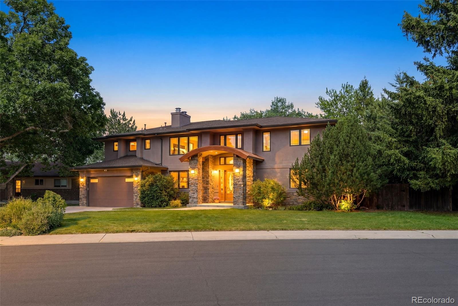 Welcome to this exceptional custom-built home in the highly sought-after Hutchinson Hills neighborhood, perfectly situated on a spacious lot backing to the serene beauty of Bible Park, with the High Line Canal creating a peaceful natural buffer. Combining luxury, functionality, and an incredible setting, this impressive residence offers five bedrooms, including a main-level office or bedroom with an adjacent full bath. Designed for both everyday living and entertaining, the chef's kitchen features a gas cooktop, two ovens, two sinks, abundant cabinetry, generous prep space, and a comfortable sitting area with a media center and second fireplace. The inviting living room is highlighted by a dramatic floor-to-ceiling stone fireplace, creating a warm and elegant gathering space. Upstairs, the luxurious primary retreat offers a private sitting area, cozy fireplace, private balcony, and an expansive spa-inspired bath. Two oversized secondary bedrooms share a Jack-and-Jill bath, while the upstairs laundry room adds everyday convenience. The finished walkout basement provides exceptional flexibility with a fifth bedroom, bonus room, full bath, second laundry and storage area, a spacious family room with a fireplace, and a stylish bar complete with a sink, dishwasher, and mini refrigerator, making the lower level ideal for entertaining guests or creating a multi-generational living area. Outdoor living is equally impressive with a covered deck, expansive composite deck, and a secluded fire pit area with a dedicated gas line, offering multiple spaces to relax and enjoy the beautifully treed surroundings. Recent upgrades include a new furnace and heat pump/air conditioning system for year-round comfort and efficiency. Surrounded by mature trees and backing to one of Denver's most beloved park and trail systems, this one-of-a-kind property presents a rare opportunity to enjoy privacy, nature, and refined living in one of the area's most desirable neighborhoods.