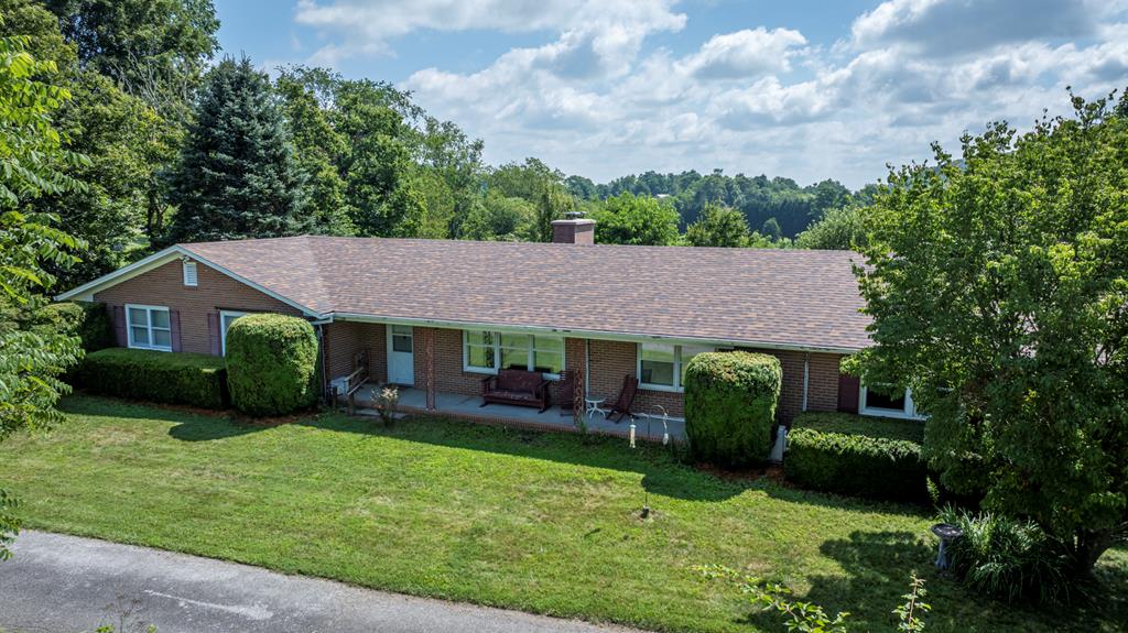 Welcome to this spacious and inviting home in the heart of Independence, VA. Tucked away at the end of a private lane, this property offers a quiet, peaceful setting away from the main road, perfect for a starting family or grandparents looking for comfort and convenience.  Set on 0.75 acres, this one-level home blends mid-century charm with thoughtful updates. Inside, you'll find 3 or 4 bedrooms, including a spacious primary suite with an updated bathroom featuring a walk-in shower, heat lamps, and a heated towel rack. One of the larger bedrooms includes custom shelving, making it ideal for a home office, library, or guest room.  Another bedroom features a hand-painted Harry Potter-themed mural creating a magical space sure to delight fans of all ages.    The living and dining area is bright and spacious, while a cozy den just off the kitchen adds additional space for relaxing or entertaining with a corner fireplace. A large mudroom/laundry room is conveniently located by the side entrance, perfect for daily use.  A full, unfinished basement with both interior and exterior access provides ample space for storage, a workshop, or potential future living space. Recent upgrades include mini-split heating and cooling systems (2023), a new roof (2024), and addition of a wood stove for supplemental/backup heating.  Step outside to enjoy a large yard with shade trees, mature fruit trees (apple, pear and peach), grapevines, blueberries, and vibrant perennials. The partially fenced yard offers privacy and room to garden or play. Relax on the welcoming front porch while watching the sunset, or start your day with the morning sun from the screened-in back porch and attached open deck.  This lovely home is within walking distance to the local library, shops, and restaurants. Located in the heart of Grayson County, you're also just minutes from the scenic New River and all the outdoor recreation the area has to offer.