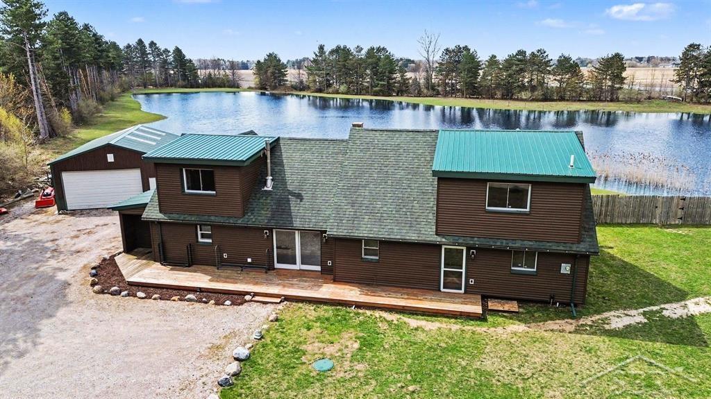 Rare blend of rustic charm and low-maintenance construction - this 2,596 sq ft log-interior home offers 3 bedrooms and 2 full baths, including a main-level master en suite and convenient main-level laundry. Relocated to the property in 2016, the house is framed with 2x6 construction, fully insulated, finished inside with genuine log siding and protected outside with durable vinyl. Major systems (roof, furnace and well) date to approximately 2016; the crawl space is insulated, lined with visqueen and equipped with a sump pump. A bright 21 x 10 sunroom overlooks the massive, approximately 20-foot-deep stocked pond and opens to the back deck - perfect for morning coffee or evening sunsets. Enjoy a sandy beach area at the pond's edge for swimming and relaxing. The kitchen features stainless steel appliances. Property amenities include a 24 x 35 pole barn, long driveway, secluded setting with abundant wildlife, RV parking, and additional parking/turnaround space. Tractor is negotiable. A survey is available. Ideal for buyers who want the warmth and character of a log home without the exterior upkeep.