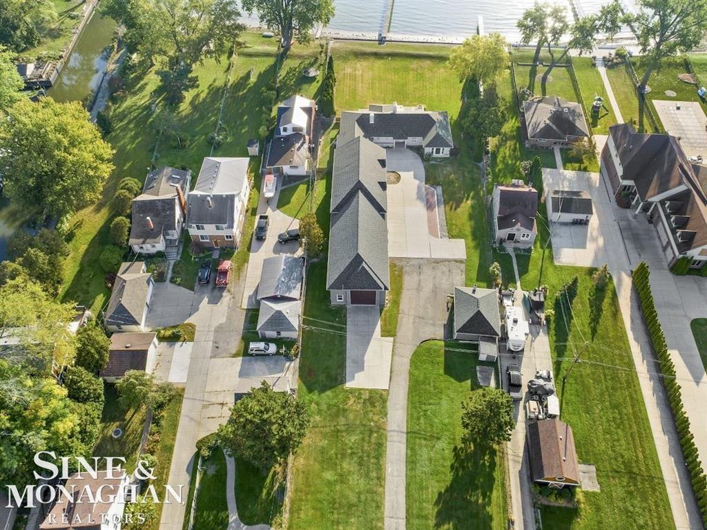 Nautical Mile Gem! Stunning waterfront opportunity with 132.5' of frontage and direct lake access on Lake St. Clair, protected by a 132.5' steel sea wall. The property features approximately 1.4 acres, a 200 ft dock, extensive new cement work, and an extraordinary 4,329 sq. ft. garage complex-unlike anything else on the lake. With 9-10 stalls, multiple 8' overhead doors into areas with roomy 10' ceilings, and a mega-sized RV bay (29' wide x 56' deep x 15'- ceilings, 14' OH door), this is a dream setup for car collectors, RV & boat owners, or anyone needing an unmatched storage & workspace capacity. The garage space includes approximately 3,741 sq. ft. attached plus 588 sq. ft. detached. While the residence allows room for updates, the seller has strategically priced at $1,249,000 based on land value, waterfront, dock, and brand-new garage enhancements including one full bathroom (stub-in prepped) plus extra-wide stairs to the approximate 2,371 sq. ft. of bonus space prepped above (with inviting vaulted ceiling areas). A rare chance to secure premier Lake St. Clair waterfront living with one of the largest garage facilities in the area. All within walking distance of restaurants, parks, new city Activity Pier, newly renovated city pool plus a new bath house in the Spring 2026, and shops. Just 5 minutes to access I94 & 696. This great family community is situated close to everything but still feels as peaceful as northern Michigan without leaving the city. Driveway accessible from a safe and quiet residential street. Only 25 minutes to visit metropolitan attractions, sporting events, concerts, casinos, entertainment & restaurants in downtown Detroit/Canada, Royal Oak & Novi.