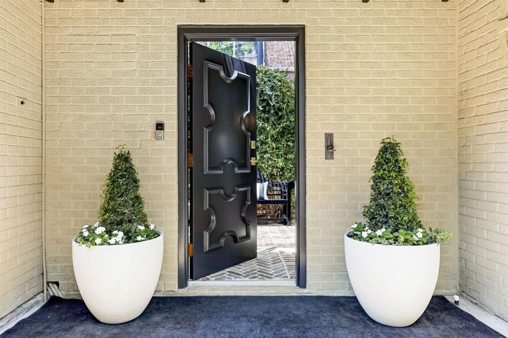 The Whitmore House is a home that continues to reveal the unexpected. Built in 1927 and thoughtfully evolved for the way we live today, this Perry Heights residence pairs historic architecture with sophisticated design, notable flexibility and spaces you simply don’t expect to find in the heart of Dallas. Inside, original character meets layers of thoughtful detail — multiple fireplaces with exquisitely detailed stone surrounds, tray ceilings, custom millwork, hidden doors and a light-filled conservatory create rooms that feel collected rather than renovated. The flexible floor plan includes two distinct primary-suite options, allowing the home to adapt easily to different stages of life. At its center, a beautifully appointed kitchen features natural marble countertops, a Wolf six-burner gas range, Sub-Zero refrigeration and Bosch dishwasher. Beyond the main living spaces, an independent one-bedroom guest house sits under the same roof as the primary residence, yet offers its own kitchen, laundry and private entrance — creating incredible flexibility for extended family, guests or additional living space. A separate conditioned studio provides dedicated space for work, art or hobbies. And perhaps one of the biggest surprises: a private motor court and rare four-car garage — almost unheard of for a home of this era and location. Outside, a Roman-inspired courtyard framed by mature ivy, herringbone brick and a fountain creates an intimate backdrop for entertaining. Historic without feeling fragile, updated without erasing its character and filled with unexpected spaces and details, Whitmore House offers something increasingly difficult to find in Dallas: a home with a true point of view.