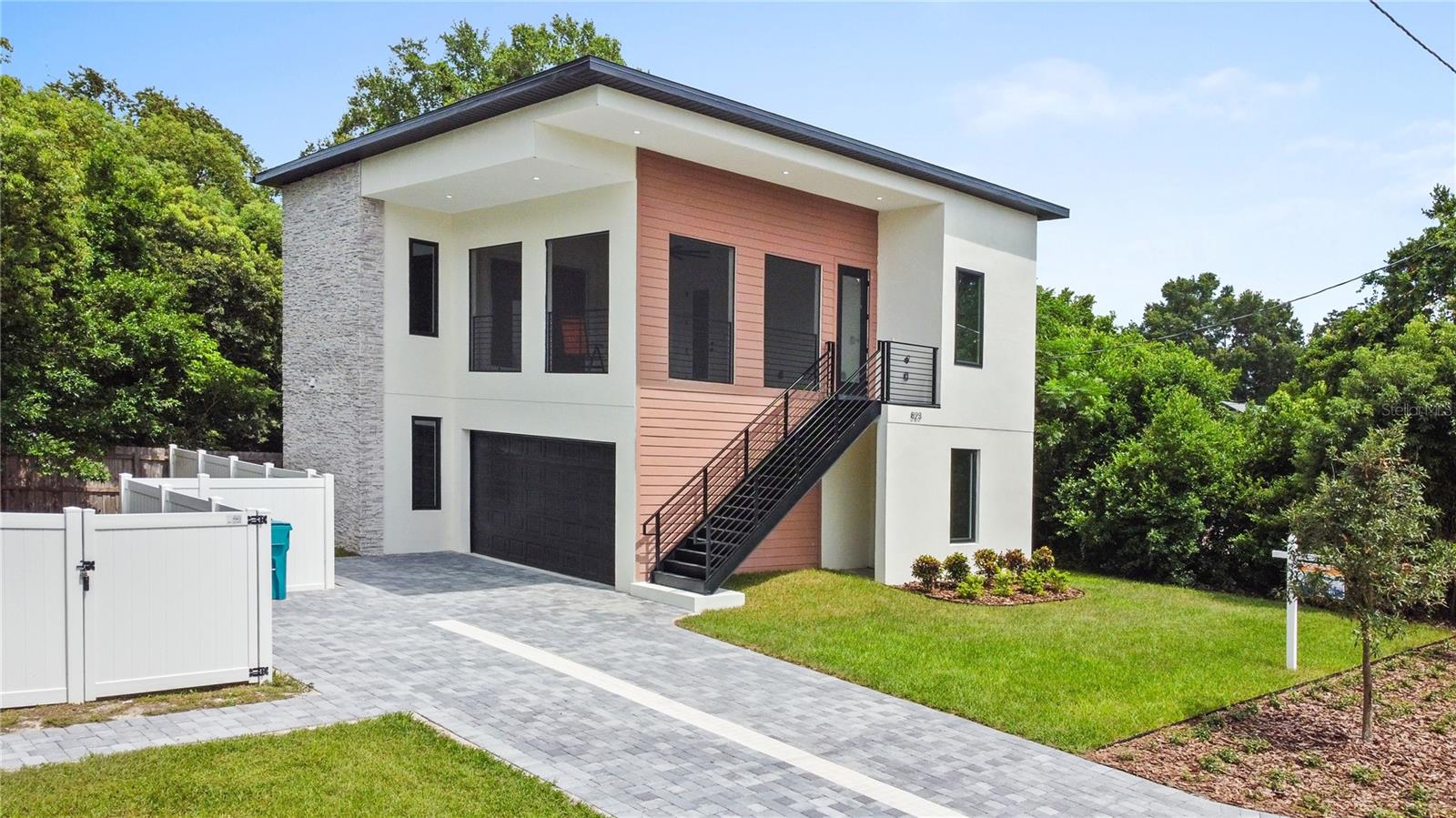 One or more photo(s) has been virtually staged. Price reduction! Stop and take in the latest in modern new construction. Located in the desirable Colonial Town neighborhood, this ultra-modern single-family home combines custom design, energy efficiency, and thoughtful functionality throughout.Spanning 1,180 square feet, this two-story residence offers three bedrooms and three full bathrooms. The first floor features the primary suite and a secondary en-suite bedroom, along with a conveniently located laundry room. Upstairs, you’ll find a spacious living and dining area, a third bedroom, and an additional full bath—perfect for guests or a home office setup.The standout feature is the expansive 18’ x 18’ screened-in balcony on the second floor, complete with turf flooring, multiple TV outlets, and plenty of space to entertain or relax.The kitchen impresses with 42-inch upper cabinets plus 12-inch glass-front extensions for added storage and style. The modern LG appliance package includes a multifunctional slide-in range with an induction cooktop and air fryer capabilities—ideal for everyday use and hosting alike.A custom-crafted front staircase enhances the home’s curb appeal, while a striking spiral staircase inside adds both character and functionality. The home’s central location is another key advantage—just 10 miles from Orlando International Airport and 20 miles from Walt Disney World. Whether commuting, traveling, or exploring Orlando’s attractions, convenience is at your doorstep. Don’t miss your chance to own this thoughtfully designed, move-in-ready modern home. New paver driveway is shared with the neighbors.Come see it before it’s gone!