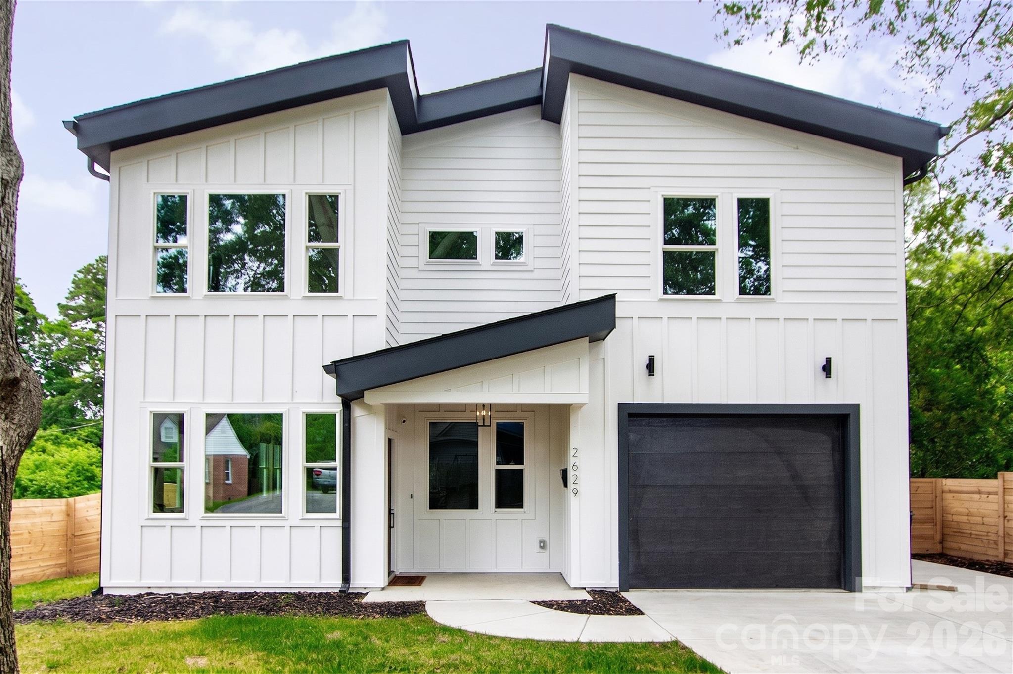 Here’s your chance to own a like-new home in thriving Revolution Park! Located just minutes from South End & Uptown, enjoy exceptional convenience to some of Charlotte’s best dining, entertainment, and employment hubs. Built only a few years ago and meticulously maintained, this modern residence blends luxury, functionality, and an unbeatable location. The light-filled open concept design is an entertainer’s dream, showcasing timeless contemporary finishes throughout. The stunning kitchen features a gas range, quartz countertops with a large waterfall island, custom hood vent, and a spacious walk-in pantry. A stylish wet bar with beverage cooler seamlessly connects to the living area, where a cozy fireplace creates the perfect place to unwind or gather. The expansive primary suite impresses with a spa-inspired bath, complete with soaking tub, walk-in shower, and generous closet space. Secondary bedrooms are well-sized with ample storage, and each bathroom showcases custom tile work and thoughtful design. Since construction, the current owners have added standout and versatile mixed-use sport court/basketball area, perfect for recreation, fitness, and entertaining. It has also been enhanced with a mini-split system creating a fully conditioned space in the insulated garage making ideal for a gym, workshop, or flex use.Enjoy outdoor living on the covered rear patio overlooking the fenced backyard. With its blend of modern design, upgraded amenities, and prime location, this home is perfectly suited for how you live, work, and play.