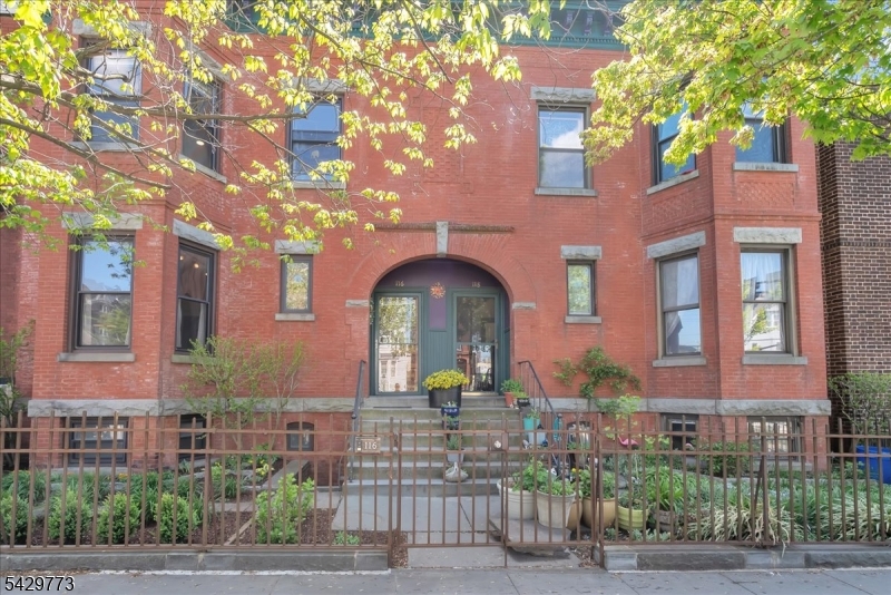 Charming Victorian row house offering 4 bedrooms and 1.5 bathrooms, blending classic character with modern comfort in Newark's Forest Hill neighborhood. Step inside through a welcoming foyer that opens to an elegant main floor filled with abundant natural light. The living room is anchored by a fireplace with an electric insert, while the dining room features a second decorative fireplace, a classic Victorian touch. The kitchen is appointed with stainless steel appliances and a breakfast bar, ideal for casual dining. A powder room finished with a stained-glass window adds charm, while original architectural details throughout the main level highlight the home's timeless appeal. Head upstairs beneath a skylight that floods the stairwell with daylight, where you'll find all four bedrooms and a full bathroom crowned by a second skylight. The primary bedroom features a walk-in closet, a rare amenity in a home of this era, with generous storage throughout. Year-round comfort is provided by a combination of radiator heat and mini-split systems for both heating and cooling. The private backyard offers a patio and dedicated barbecue area, perfect for outdoor entertaining or quiet relaxation. Ideally located near Branch Brook Park with views of the iconic Cathedral Basilica of the Sacred Heart, this home also offers excellent commuter convenience, with a nearby light rail station providing easy access to Downtown Newark in under 10 minutes and onward connections to Hoboken and NYC.