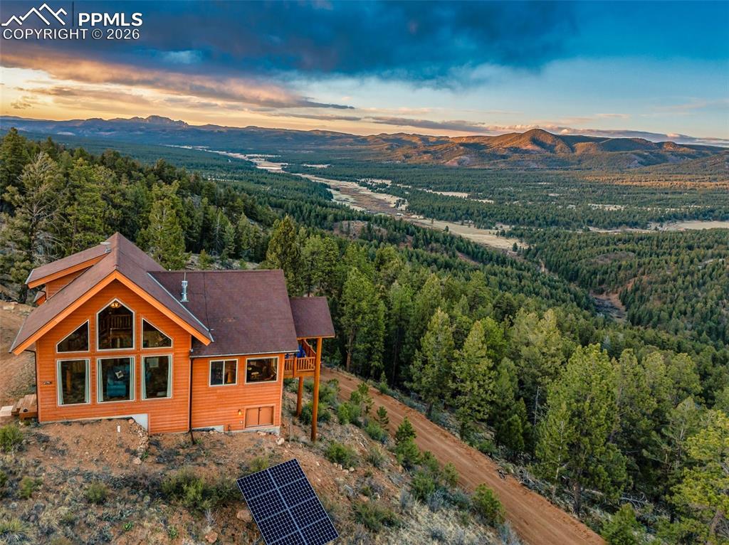 49.64 acres. Completely off-grid. Just 52 feet from the Pike National Forest. Spectacular 360-degree mountain views in every direction. This is the Colorado mountain property you have been searching for. Tucked away with total privacy yet only 10 minutes from downtown Woodland Park, this 2 bedroom, 1 bathroom, 1,480 square foot off-grid home sits on nearly 50 acres of pristine Teller County land. Whether you are looking for a mountain retreat, a homestead, or a forever home surrounded by nature, this property delivers on every level. Step inside to find hand-peeled beams and custom woodwork throughout, a stunning two-sided gas fireplace, and the warmth of true mountain craftsmanship. The home was constructed with green built structural insulated panels for superior energy efficiency, finished with durable Hardyboard siding and equipped with lightning protection on the roof. The off-grid power system has been fully upgraded with a 24-volt solar array featuring new panels, a new inverter, and three new lithium ion batteries. A backup generator and on-site propane provide additional reliability year-round. The well produces an exceptional 7 gallons per minute, and Starlink satellite internet is included for high-speed connectivity in even the most remote settings. Outside, the land is nothing short of breathtaking. Live water flows through the property along a creek, attracting abundant Colorado wildlife including moose, bear, elk, and deer. With direct access to National Forest trails from your doorstep, this is a paradise for hiking, hunting, horseback riding, and outdoor recreation in the Pikes Peak region. This is one of the most unique off-grid properties for sale near Woodland Park, Colorado. Seller is willing to negotiate on furnishings and a tractor to make this a truly turnkey mountain living experience. Schedule your private showing today.