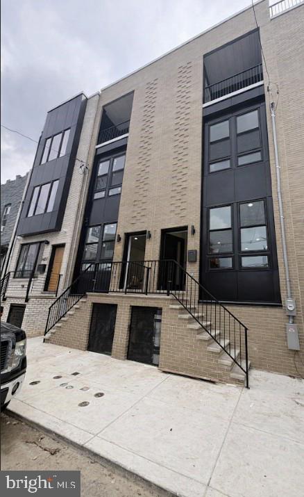 This exceptional home offers thoughtfully designed living space across four levels. The main floor features an open-concept layout that flows seamlessly from the spacious living room, complete with a modern electric fireplace, into the dining area and custom kitchen. The kitchen is equipped with ample lower cabinetry, a designated exhaust for the cooking range, a water line for added convenience, and a stunning waterfall island featuring a built-in microwave and dishwasher with plenty of room for bar stool seating. Double sliding doors lead to the rear yard, which includes a green space area and attractive white fencing. The second floor offers two generously sized bedrooms and two full bathrooms, including a front bedroom with a private en suite bath. Both bedrooms feature ample closet space, beautiful exterior views, and oversized windows that fill the rooms with natural light. This level also includes a spacious hall bathroom, laundry area, and separate utility room. The third floor is highlighted by an impressive primary suite featuring double glass sliding doors that open to a private balcony with unobstructed views and a separate outdoor storage closet perfect for outdoor furniture. A large walk-in closet leads to a beautifully customized bathroom with a double vanity, oversized walk-in shower, and luxurious waterfall shower fixture. An additional room on this level offers flexible use as a bedroom, office, or sitting room and includes double glass sliding doors leading to a private east-facing deck with scenic views. A separate hallway provides access to the rooftop deck, where panoramic city views create the perfect setting for relaxation or entertaining. The fully finished basement offers even more versatile living space and can easily serve as a fourth bedroom, guest suite, home office, or recreation area. This level also includes a separate mechanical room, a convenient half bathroom, additional closet and storage space, and a large entertainment area, making it an ideal extension of the home's comfortable and functional layout. Conveniently located near public transportation, shopping centers, Center City, and all that vibrant Passyunk Square has to offer!