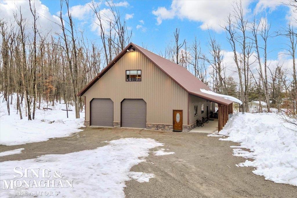 This extraordinary, one-of-a-kind barndominium is everything you imagine when you dream of the perfect up-north escape-crafted with intention, designed with character, and finished with no detail overlooked. More than just another Northern Michigan property- this is a lifestyle. Every inch of this home has been thoughtfully curated. From locally sourced timbers that frame the stunning custom full bar to the hammered copper countertops and carefully selected reclaimed and vintage elements throughout-this property blends rustic charm with refined, modern comfort in a way that is truly unmatched. The recently completed upper-level living space offers a warm and inviting retreat, featuring a spacious primary suite with a cozy sitting area and a spa-like bath complete with heated floors, a walk-in stone shower, dual marble vanities, a linen closet, and generous his-and-hers closets. Designed for gathering, the open-concept kitchen, dining, and living area is perfect for entertaining. Enjoy a large eat-in nook, stainless steel appliances, granite countertops, and access to a private balcony overlooking serene lake views. Two additional sleeping areas and a full bath-also featuring heated flooring-provide ample space to host family and guests with ease. Set on 10 beautiful acres directly across from Big Bear Lake, this property is an outdoor enthusiast's dream. The expansive barn is built to impress, offering heated floors throughout, making it ideal for year-round use, storage, or housing all of your recreational toys. With immediate access to trails and endless room to roam, adventure is right outside your door. Ideally located just minutes from Lewiston, approximately 30 minutes to Gaylord, and under an hour to Boyne Mountain. Additional features include a striking live-edge custom staircase with ambient lighting and a comprehensive audio and video surveillance system throughout the interior and exterior of the property. An amazing opportunity to own a truly unforgettable Up North retreat.