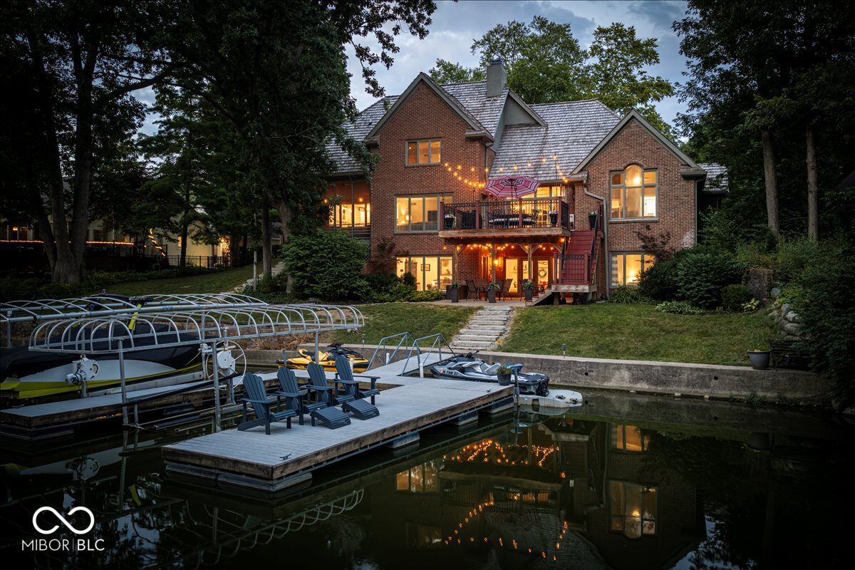 Breathtaking GEIST WATERFRONT property, located in Fishers (HSE Schools), at a price that's hard to find! Offering nearly 5000 sq ft, this FORMER HOME-A-RAMA custom estate was created by acclaimed master builder Steve Ham. You will adore the incredible floor plan, featuring a MAIN LEVEL OWNERS SUITE, 4.5 bathrooms, a NEWLY REMODELED WALKOUT BASEMENT, 3 fireplaces, gorgeous mature trees & PRIVATE ACCESS to a boat dock that accommodates two vessels & jet skis! Located on the charming Gulfstream Dr, this property not only exudes elegance & striking features but is also packed with updates, elevated finishes & walls of windows with water views. The main level includes a stately office with built-ins & glass door, an elegant dining room just a few steps away from the kitchen, an inviting great room w/gas fireplace & soaring ceiling, a cozy heart room that's open to a gorgeous (& remodeled) gourmet kitchen w/center island, SS appliances, breakfast nook & access to the back deck w/water views! The main level also features a spacious & elegant owners suite w/vaulted ceiling, access to the back deck, a luxurious & updated spa bathroom w/dual vanities & a stunning tiled WI shower + access to a HUGE custom WI closet! The upper level is the perfect size & features a loft, two large secondary bedrooms, both w/access to a full bathroom. The upstairs also offers an unfinished attic, perfect for a future lounge, 2nd office, game room, craft room & more! The stunning walkout basement was recently remodeled & includes a great room, bar area, 4th bedroom w/patio access, full bath, storage room & just steps away from the boat dock & water! The list of updates is long, but here are a few standouts: roof replaced in '18, new exterior doors, new flooring, upper level HVAC '20 & more! You will adore the location, minutes from shopping, dining, the marina, florist, Moody's Butcher Shop, Geist Coffee, miles of paved trails & Daniels Vineyard!