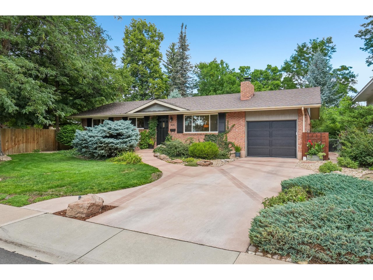 Welcome to this meticulously loved all-brick ranch in desirable South College Heights, where timeless character, thoughtful updates, and inviting outdoor spaces create the perfect setting for Colorado living. From the moment you arrive, the scene is set with lush landscaping, decorative boulders illuminated by built-in lighting, and a custom-designed concrete driveway. Step inside to beautiful wood floors and a spacious living room filled with natural light from the picturesque front window. A cozy fireplace with a wood mantel invites you to settle in for fireside evenings at home. The primary suite and versatile second bedroom-perfect for guests, a home office, music room, or creative space-are both situated on the main floor. Channel your inner chef in the updated kitchen, featuring luxurious hard-surface countertops, chic marble backsplash, and a distinctive distressed-wood accent wall. The adjoining dining area is ideal for everything from quick breakfasts to relaxed evenings with friends. Downstairs, the finished basement offers two additional bedrooms, a large recreation area, inviting bar, full bathroom, laundry room with utility sink, and plenty of storage-giving everyone room to spread out and have some fun! The backyard is the true showstopper. Mature trees and lush landscaping create a private retreat with multiple places to unwind. Enjoy summer dinners and BBQs on the composite deck with built-in seating or retreat just beyond to a second outdoor living area with trellis and tucked among mature trees-perfect for morning coffee or an evening beverage. A storage shed keeps bikes, gardening tools, and recreational gear tucked away, while the one-car garage is wired for EV charging. Close to O'Dea Elementary, CSU, Old Town, parks, trails, shopping, dining, and everyday amenities, you're in the heart of it all. It's Colorado living at its finest!