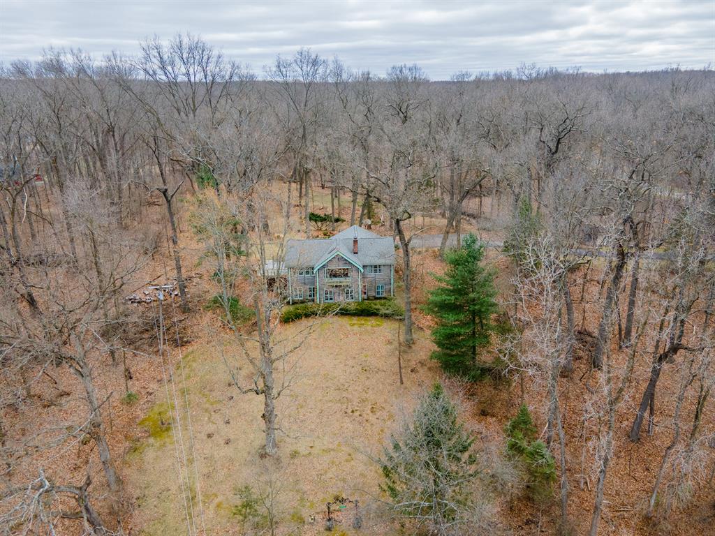 Offer Deadline: Sunday, June 8 at 7pm. Step into a rare slice of Michigan history with this enchanting log home, nestled on over five wooded acres with access to Strawberry Lake. With sweeping views this property blends rustic charm, modern comfort, and unforgettable character. The main ranch-style home boasts a spacious eat-in kitchen, formal dining room, and an impressive great room with cathedral ceilings, a cozy gas stove with floor-to-ceiling brick surround, and views that stretch all the way to Strawberry Lake. Two main-floor bedrooms offer flexibility--one with a generous walk-in closet, and the other with an attached private office, ideal for remote work or creative pursuits. A beautifully tiled, zero-entry shower enhances the full main-floor bathroom.The walk-out lower level offers incredible versatility, functioning as a potential in-law suite or self-contained apartment. It features daylight  a full kitchen, a large living area, an oversized bedroom with a gas fireplace, a massive full bathroom, a laundry area with ample storage, and a charming under-stair storage nook. Follow the flagstone pathway to the expansive deck with tempered glass balustrades overlooking a serene, tree-covered landscape with rolling hills and a peaceful creek winding through old-growth treesperfect for nature lovers and entertainers alike.
Wooded and private with creek frontage, it's a nature lover's dream with limitless potential. Additional highlights include paved road, charming vintage features like original candelabras, historic light fixtures, skylights, storage spaces and built-in shelves throughout, and antique hardwareall just minutes from downtown Dexter.