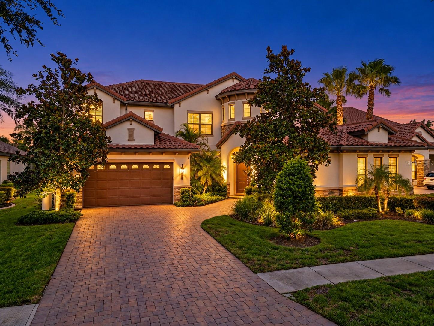Tucked at the end of a quiet cul-de-sac behind the guard gates of Grand Hampton, this 6-bedroom, 3.5-bath residence offers more than 3,500 square feet of refined living on an expansive 0.32-acre homesite. Mediterranean-inspired architecture, a classic tile roof, paver drive, and mature landscaping set an elegant tone from the moment you arrive, while a newly installed HVAC system speaks to the care with which this home has been maintained.A gracious covered entry opens to a welcoming foyer and a light-filled living room crowned by soaring cathedral ceilings. The open floor plan flows seamlessly between gathering spaces, with wood flooring throughout the main living areas, granite countertops, and stainless steel appliances. The first-floor owner's retreat is privately situated and features a spacious walk-in closet and a spa-inspired bath with a soaking tub, enclosed shower, and separate vanities. Also on the main level, a versatile sixth bedroom serves beautifully as a guest room or private home office. Upstairs, four additional bedrooms and two full baths provide generous space and privacy for everyone.Outdoors, a covered lanai extends to a private resort-style oasis, where a shimmering in-ground pool and spa sit beneath a full screened enclosure framed by lush tropical landscaping. Beyond the enclosure, a generous expanse of lawn offers a rare amount of open green space for a pool home of this caliber. A three-car garage completes the picture.Grand Hampton residents enjoy a clubhouse, fitness center, and beautifully maintained grounds, all with convenient access to premier shopping, dining, and major thoroughfares. An exceptional home in an exceptional setting.