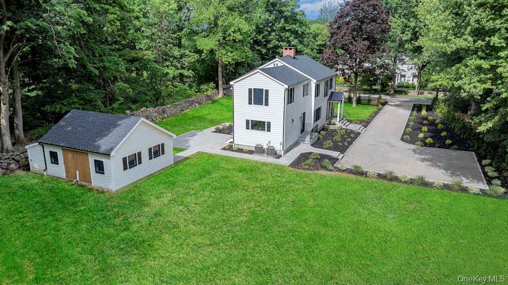 Renovated and Reimagined Colonial on Spectacular Park-Like Grounds, this exceptional residence includes a separate cottage-style bonus building that offers endless possibilities. Whether envisioned as a private home office, artist’s studio, wellness retreat, yoga or fitness center, man cave or an inspiring creative workspace, this detached structure provides exceptional flexibility and privacy. Nestled amid the lush grounds and mature landscaping, it serves as a peaceful extension of the home and creates a rare opportunity for today’s work-from-home lifestyle or entrepreneurial pursuits. At the heart of the home, an original stone wood-burning fireplace serves as a stunning focal point, infusing the living space with warmth, character, and timeless charm. Perfect for cozy winter evenings, holiday celebrations, and memorable gatherings with family and friends, this impressive architectural feature creates an inviting atmosphere that embodies the true spirit of home. The stunning chef’s kitchen features premium stainless-steel Thermador appliances, elegant quartz countertops, a spacious walk-in pantry, and seamless access to an oversized slate patio—ideal for indoor-outdoor entertaining. The captivating primary suite offers soaring beamed ceilings, a generous sized walk-in closet, and a luxurious spa-inspired bath complete with dual vanities and a classic clawfoot soaking tub. Convenient second-floor laundry with storage enhance everyday living. Additional highlights include all-new Anderson windows, all new electrical, all new plumbing, new roof, new c/air, new Navien system, energy-efficient blown-in insulation, solid wide-plank oak flooring, and exquisite custom millwork throughout. The separate cottage building has all new electrical, blown insulation, windows, flooring and roof.  Located minutes from the Metro North Train Station and downtown Chappaqua, you'll have quick access to commuter routes and a charming village filled with shopping, restaurants and community events. A rare offering that perfectly blends timeless charm with sophisticated modern updates, all set within a serene and private setting designed for both relaxation and entertaining.