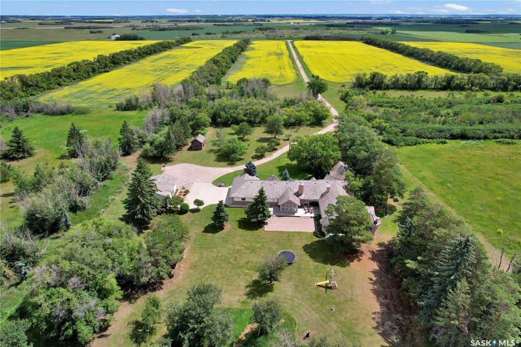 Maple Hedge Historical Home Site is a truly unique property—the first lot in the upcoming Maple Hedge Estates, a beautiful new country residential development featuring over 250 acreage lots on three quarters of land. This 14-acre site offers a spacious 4,201 sq ft bungalow nestled among mature trees, with a triple attached heated garage, double detached shop, and barn. Built in 1993, the home includes six bedrooms, seven bathrooms, and a basement studio—ideal for extended family or nanny suite. The tour begins with a tiled front foyer that leads into a bright reception room with large windows and skylights. A private study overlooks the front yard and shares a two-sided wood-burning fireplace  and a two-piece bath with the reception room. The main wing features a gourmet kitchen with cherry wood cabinets, walk-in pantry, dual built-in ovens, large island with gas cooktop, and breakfast nook with sunny east views. A sunken living room with wood-burning stove opens to a beautiful sunroom overlooking the backyard with access to a large deck and patio space. Down the hall are two bedrooms with en-suites, a mudroom, and access to the heated triple garage. The south wing offers three more bedrooms, one with an en-suite, a main bath, and a luxurious primary suite with gas fireplace, sitting area, walk-in closet, and a five-piece en-suite. The large laundry room leads to the basement studio that adds flexible living space. The meticulously maintained grounds offer privacy, green space, and room to play. The barn provides excellent storage or animal use, and a zipline from the hayloft to near the house adds family fun. This property also includes an investment opportunity with an option to include two adjacent lots for only $100.00 each providing future profit and control of the land just south of the home A rare combination of estate living and investment potential. Call today for your private showing.