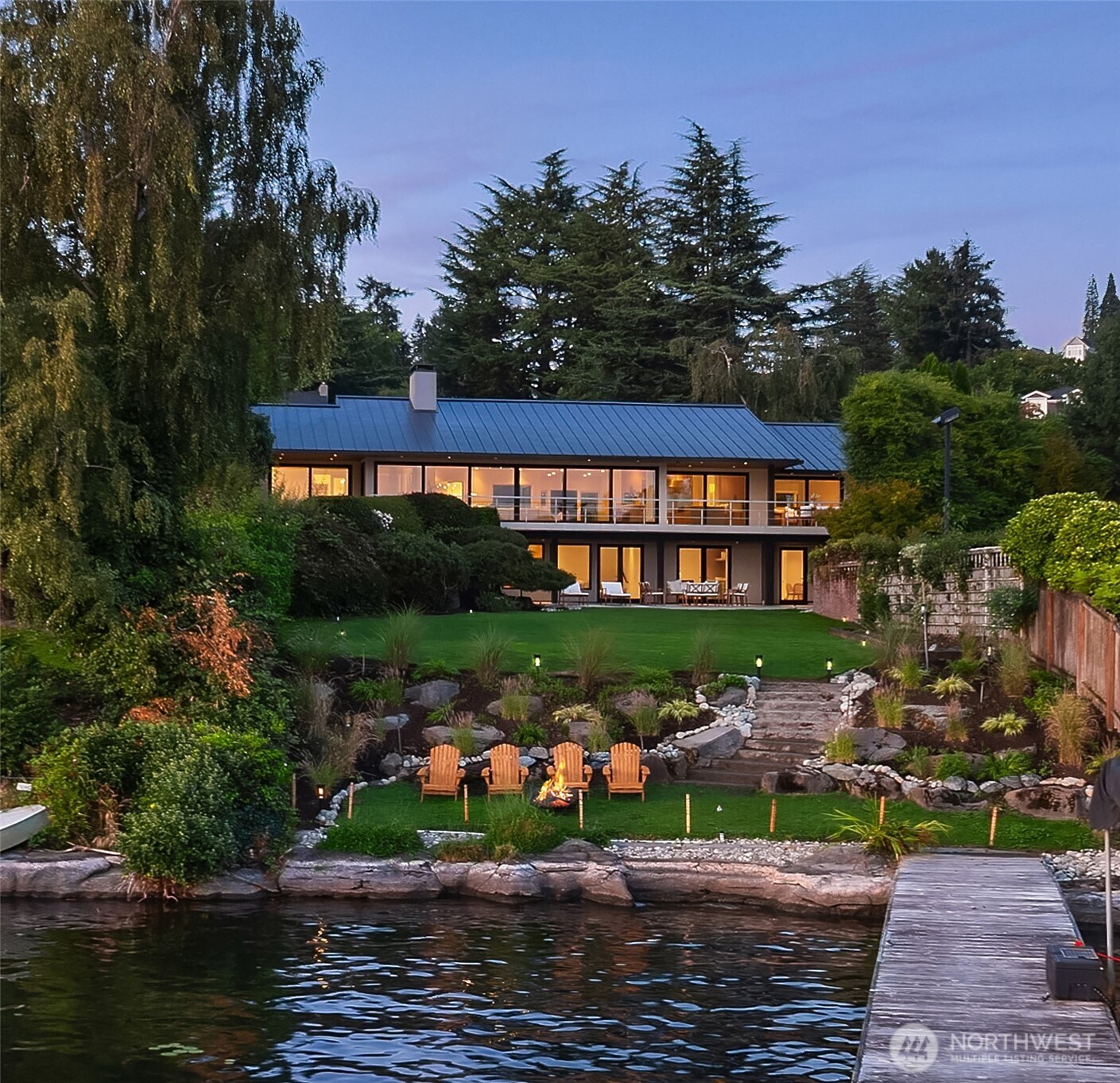 Once you’ve lived on the water, you know what to look for: south-facing exposure with beautiful all-day light. Flat, usable land. Low-bank waterfront with an expansive lawn. And a home designed equally well for everyday life and entertaining. Simple, but rare.    Set on an extraordinary 21,008SF private waterfront lot in Laurelhurst, this nearly 6,000SF home has been transformed through two phases of designer-led renovation, pairing thoughtful craftsmanship with the scale of a true estate property. Walls of glass frame expansive lake views, while the floor plan unfolds naturally toward the water.    The main level offers open kitchen, living and dining spaces, a built-in bar and butler’s pantry, dedicated office, ensuite bedrooms, and a massive level-entry garage. The daylight lower level adds a full MIL, with its own laundry, dedicated fitness studio with custom Tracy Anderson flooring, and flexible bonus room for a fifth bedroom, office, or studio. Outside, a covered patio and sweeping level lawn lead directly to the water.    Rift-cut white oak floors, richly textured Ann Sacks tile, high-end appliances and considered finishes create a warm, restrained palette. With five bedrooms, five baths and a powder room, the home also offers exceptional infrastructure, including a 50-year metal roof, three heat pumps, two furnaces, dual 80-gallon water heaters, and three laundry sets.    The result is a quiet sophistication—and a waterfront setting that simply cannot be recreated.