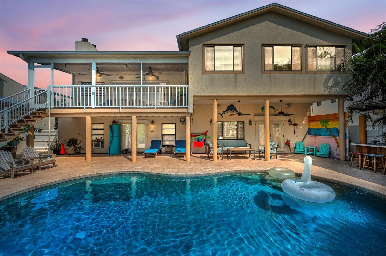 Step into your very own HIGH & DRY tropical oasis on the water, where swaying palms, a sparkling pool, and a fully-equipped outdoor kitchen with a brick pizza oven set the scene for resort-style living in the sought after community of Palm Harbor. This stunning 4-bedroom, 3.5-bath home offers the perfect blend of comfort, luxury, and Florida charm, all while including a mother-in law suite!

Inside, you’ll find an open-concept floor plan featuring high ceilings, elegant wood floors, and spacious living areas designed for entertaining and spending time with loved ones. Oversized windows and sliding glass doors flood the space with natural light and provide seamless views to the tropical backyard and water beyond. The living and dining rooms are thoughtfully connected, offering flexibility in layout and a true sense of openness. The gourmet kitchen is one of the best features of the home, featuring high-end appliances, granite countertops, custom cabinetry, and a large center island with bar seating — all flowing naturally into the main living space for easy entertaining. The family room features a cozy fireplace, creating a warm and inviting atmosphere — perfect for cooler Florida evenings. You will also find how the family room flows effortlessly out to the screened in patio that overlooks your coastal backyard, making indoor-outdoor living a breeze.

Upstairs, the primary suite boasts tranquil views over the tropical paradise backyard, a spa-like ensuite, and a generous walk-in closet. Two additional bedrooms and a full bath complete the upper level for perfect family living.

Moving downstairs you will find an additional living room perfect for entertaining, a freshly remodeled laundry room, and a half-bath that dually serves as a pool-bath. On the first floor you will also find a mother-in-law suite that includes its own private entrance that offers privacy and flexibility for guests, all while offering a full kitchen, living room, bedroom, and bathroom.

Outside is where this home truly shines — your own slice of paradise with: a gorgeous pool surrounded by tropical landscaping, water access with a dock and boat lift davits that drop you just minutes from the Intracoastal, a built-in outdoor kitchen with grill and wood-fired brick pizza oven, covered patio perfect for dining, and a pavilion and storage shed.

Other features include a 2-car garage, partial impact windows, hurricane shutters, smart home upgrades, and a prime location just minutes from top-rated schools, beaches, the Sponge Docks, and downtown Palm Harbor and Tarpon Springs.

This is more than a home — it's a lifestyle. Don’t miss your chance to own one of Palm Harbor’s most inviting waterfront escapes!

NOTE: Home did NOT flood in the 2024 hurricanes and sits elevated from the canal.