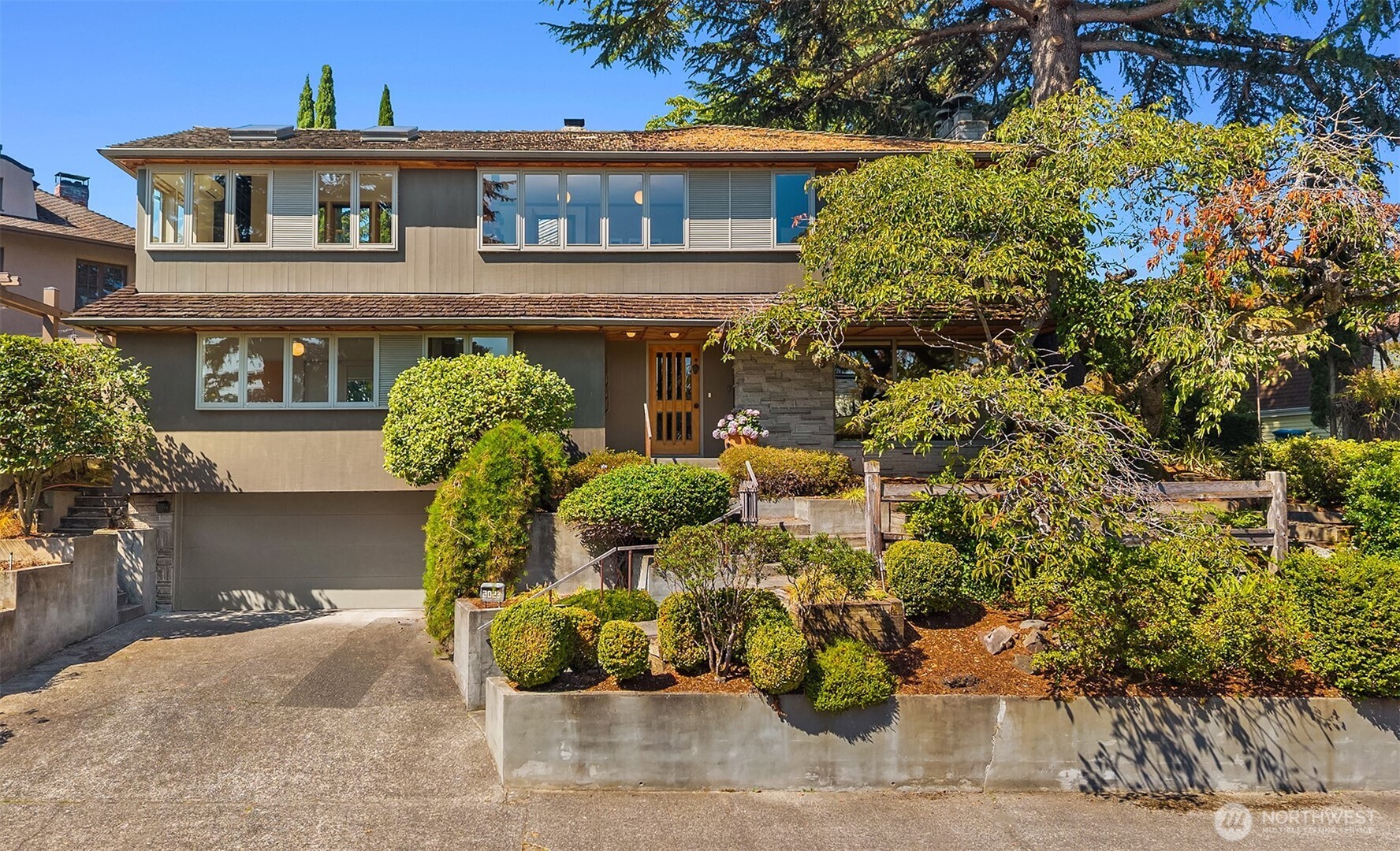 Beloved family home of 60 years, nestled at the end of coveted Webster Point in Laurelhurst, set on two tax parcels. Expansive interior spaces offer varied views of Lake Washington & Mt. Rainier, coupled w/private outdoor landscapes, including a spectacular sculptural cherry tree that will make you feel you're in Kyoto. Classic mid-century elements, such as floor-to-ceiling windows, bring the outside in, framing nature & doubling room size optically. Home to an artist & a master craftsman, both figure beautifully in its history. The woodwork is exquisite, w/elegant detailing throughout, well beyond the norm. The upstairs studio is a dream workspace, flooded w/light, a picture-perfect view of lake and mountain & plenty of room to create.The kitchen is the heart of the home, w/vaulted ceilings, built-in banquette, granite island w/prep sink, & a wet bar opening to the back patio for true indoor-outdoor living. Double ovens, professional gas range, Sub-Zero fridge w/2 additional drawers, & a trove of clever built-ins (yes, a silver drawer) reward the curious. A Dutch door leads to a spacious patio & park-like yard beyond. On the second floor, a primary retreat includes a sitting area, walk-in closet, gas fireplace, & a private porch under a tree canopy. A fabulous retro rumpus room in lower-level w/original vibe. This home has a warm, nurturing feel, private and serene. Move in & enjoy as-is, or remodel to make it entirely your own. A canvas ready for the next life's work.
