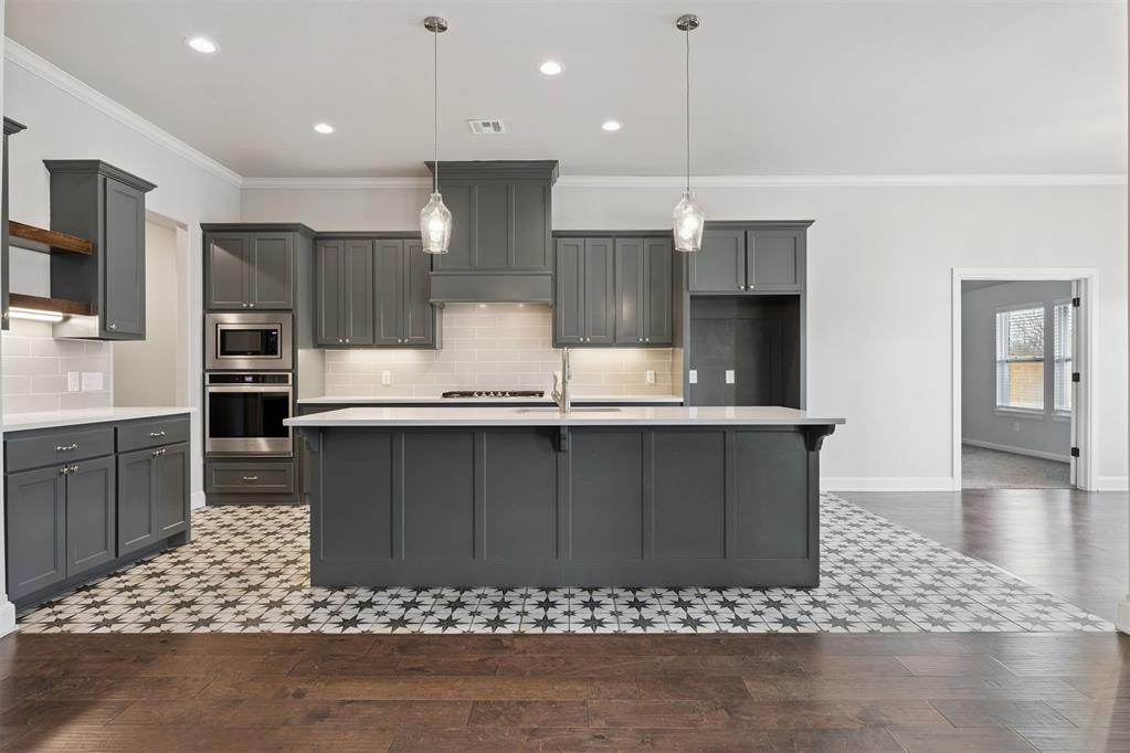 Beautifully custom-built by Beacon, this nearly new home is tucked into the highly desirable Deer Creek community and sits on a premium, private lot backing to peaceful wooded views. With its fresh, modern finishes, this home offers the appeal of new construction without the wait.Set on a spacious .83-acre lot with a sprinkler system, the property provides privacy and room to enjoy every season. The expanded patio and outdoor fireplace create an ideal space for entertaining, grilling, or relaxing year-round.Inside, the home features a bright, open-concept floor plan filled with natural light, crisp finishes, and carefully selected upgrades throughout. The kitchen is a standout, offering a large island perfect for seating, serving, and storage, along with abundant cabinetry and a generous pantry.The oversized living area showcases serene views and is well suited for both everyday living and entertaining. The primary suite includes an adjoining flex space—ideal for a study, playroom, or hobby room—while the thoughtfully designed laundry room includes a sink for added convenience.A split-bedroom layout allows for flexibility across a variety of living arrangements, and the 3-car garage features a highly desirable storm shelter. Be sure to review the full list of upgrades—this like-new home is truly move-in ready. Schedule your private showing today!