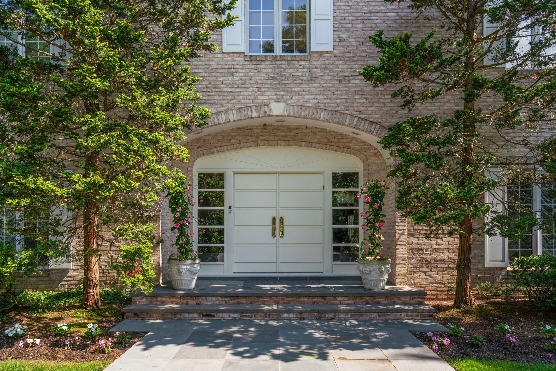 Welcome to this Magnificent Brick Masterpiece with Guest/Pool House on Two Impeccable Resort Style Acres. This Grand Residence sets High Standards for a lifestyle of luxury offering timeless elegance and luxurious modern amenities. Sophisticated designer finishes are blended with classic appointments throughout it's refined and thoughtfully designed Interior. A stunning marble reception foyer with sweeping staircase sets the tone, opening to expansive and beautifully detailed principle rooms. The formal Living Rm w white marble mantle, high ceilings, beautiful moldings & large picture windows overlooking gardens provides for elegant entertaining while guests will be delighted to dine in the richly appointed Dining Rm with inlaid floors and large Palladian window.  A 2nd Gracious Foyer holds an exquisitely appointed Powder Room, and large Guest Closet leading to the handsome walnut Office/Library w coiffured ceiling & fireplace and a generously proportioned cherrywood Den/Family Room with fireplace, ideal for extended entertaining or relaxed everyday comfort. The bespoke chef's kitchen showcases an abundance of custom cabinetry for exceptional storage, seamlessly blending style and function. Outfitted with premium appliances and anchored by a sunlit breakfast room overlooking the pool and pristine landscaping, the space is both elegant and practical. Sliding French doors open to an expansive bluestone patio with built-in BBQ, ideal for effortless indoor-outdoor entertaining. A well appointed butlers pantry is convenient for entertaining. Set privately off from the kitchen is a first floor Bedroom & Beautiful Full Bath.  Occupying a prime position on the upper level, the luxurious primary suite offers a serene retreat featuring spacious sunlit sitting room with fireplace, a lavish spa-inspired marble bath and two walk-in closets. On this same floor are two generous bedrooms with a shared bath and a beautiful third bedroom with private bath that connect by an expansive circular hallway overlooking the grand entrance foyer. The lower level is finished with large storage closets, multiple rooms for play and watching TV, a game room with a built-in wall of cabinetry and half bath. The grandeur continues as you step onto pristine bluestone patios surrounded colorful gardens and sweeping green lawns. A beautifully appointed Pool House offers a full kitchen, spacious living room, full bath and private dressing room-providing the perfect retreat for guests or seamless indoor-outdoor entertaining. The attached covered patio with built-in ceiling heaters & wall mounted television invites year round enjoyment, all overlooking the sparkling resort-style pool and elevated spa for the ultimate in relaxed luxury. 3 car garage, Locust Valley SD  By Appointment