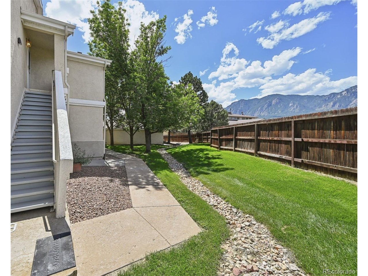 Tucked quietly away in a secluded west side of the complex, this beautifully maintained 3-bedroom, 2-bath, 1 car garage and 1 carport condo offers privacy, comfort, and plenty of shaded green space just outside your front door. Used as a second home and lovingly cared for over the past 20 years, this home is truly move-in ready. The inviting living room features a gas fireplace for cozy Colorado evenings, while the beautiful breakfast bar creates the perfect spot for morning coffee or casual meals. Step out onto the walkout patio and enjoy mother nature as refreshing mornings begin and fulfilling evenings come to an end. The primary suite overlooking the open green landscape offers a large walk-in closet and relaxing soaking/jacuzzi tub. Beautiful mountain views and thoughtful touches throughout the home include custom shades, a kitchen pantry, large wall storage cabinet, and a laundry closet with the washer and dryer included. The refrigerator, just two years old, also stays. Upper level living in a gated community with paid night security for added peace of mind. Maintenance-free landscaping, with someone else taking care of snow removal and best perk yet....the keyless entry garage! You own it-this is not an assigned or leased garage. It's yours and an added value to your investment, providing added convenience and security, along with valuable overhead storage. An additional assigned one-car carport provides even more parking. Looking for more? The Country Club has it to include exercise and meeting rooms, large kitchen and open common area for large gatherings, tennis, pool and hot tub. Yes, this is home! Conveniently located near Cheyenne Mountain Zoo, Seven Falls, Fort Carson, Pikes Peak State College, I-25, Highway 115, and many of Colorado Springs' favorite attractions. A private-feeling setting, maintenance-free lifestyle, and the rare benefit of an owned garage make this condo a wonderful place to call home.