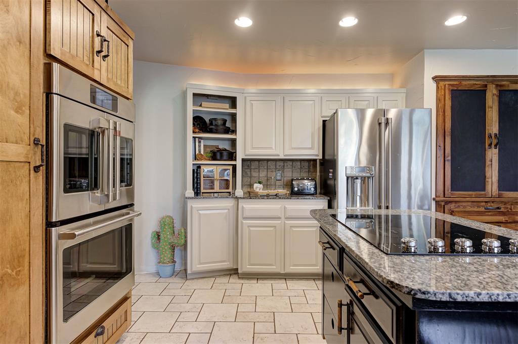 Welcome to this unique and beautifully updated property offering exceptional indoor and outdoor living. This spacious 4-bedroom, 3.5-bath home is filled with custom details, thoughtful design, and versatile spaces.The home offers a one of a kind office/flex space featuring a wood-burning fireplace, built-in shelving, a built-in fireproof safe, and cedar walls, making this space ideal for a home office, entertaining or a cozy evening by the fire!The sunken living room with its rock accent wall, fireplace, and built-in bookcases, open up to the dining room and full size bar equipped with a sink and space for a wine fridge and kegerator!The dining room is an entertainer’s dream with glass doors that open to a spacious covered patio. Enjoy year-round gatherings with plenty of room for outdoor seating and a charming wood-burning stove.The chefs kitchen is truly special with custom cabinetry, pull-out shelving, a built-in lazy Susan, walk-in pantry, with additional storage under the staircase plus a custom-built pantry. Some high-end upgrades include a GE Café double oven with French doors on top, GE Café bottom-freezer refrigerator with ice-in-door and hot-water dispenser.Downstairs the primary suite feels like a retreat, with a spa-like bathroom featuring a steam bath and walk in shower. The sliding doors open directly to the pool area, while the flex room off the primary suite offers endless possibilities—use it as storage for pool essentials, a dressing room, or extra closet space. The other 3 beds and bathroom are located upstairs as well as lots of built in storage!This property offers two lots, mature trees, a custom built bridge leading to the  adjoining lot, a greenhouse, raised garden beds, a chicken coop with a fenced run, a carport, wood shed and a beautiful pool with a waterfall feature and separate fence. Whether hosting gatherings, relaxing by the pool, gardening, or enjoying recreational activities, this property truly offers it all!