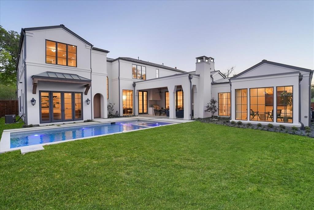 New Construction in the fairway of Preston Hollow. Discover a harmonious blend of timeless elegance and contemporary design at 6031 Lupton Dr. Nestled on a .43-acre lot in the prestigious Fairway of Preston Hollow, this 7,009-square-foot estate features 5 bedrooms, 5.2 baths, and a three-car garage, offering both luxury and comfort in every detail. The exterior draws inspiration from the iconic Santa Barbara style, merging the romance of Spanish Revival architecture with a fresh coastal aesthetic. Handmade details transition seamlessly from the outside in, with corbel arched openings, beamed ceilings, and warm wood tones enhancing the home’s inviting atmosphere. The interiors are adorned with limestone and plaster fireplaces, custom vent hoods, and decorative cement tiles, all contributing to the classic Mediterranean ambiance. Inside, rift-cut white oak cabinetry, warm white walls, and a mix of travertine and quartzite stone create a modern yet welcoming feel. The thoughtful balance of polished nickel with wrought iron and bronze tones adds a touch of sophistication, ensuring the home retains its Mediterranean roots while embracing contemporary style. This home also boasts two laundry rooms for added convenience, a dedicated office space, and expansive living areas perfect for both relaxation and entertaining. The backyard is an inviting retreat featuring a covered patio, built-in outdoor grill, and a sparkling pool, perfect for relaxing or entertaining. 6031 Lupton Dr. is not just a home; it's a masterpiece of design, where traditional craftsmanship meets modern luxury. Experience the best of both worlds in this exquisite Preston Hollow home.
