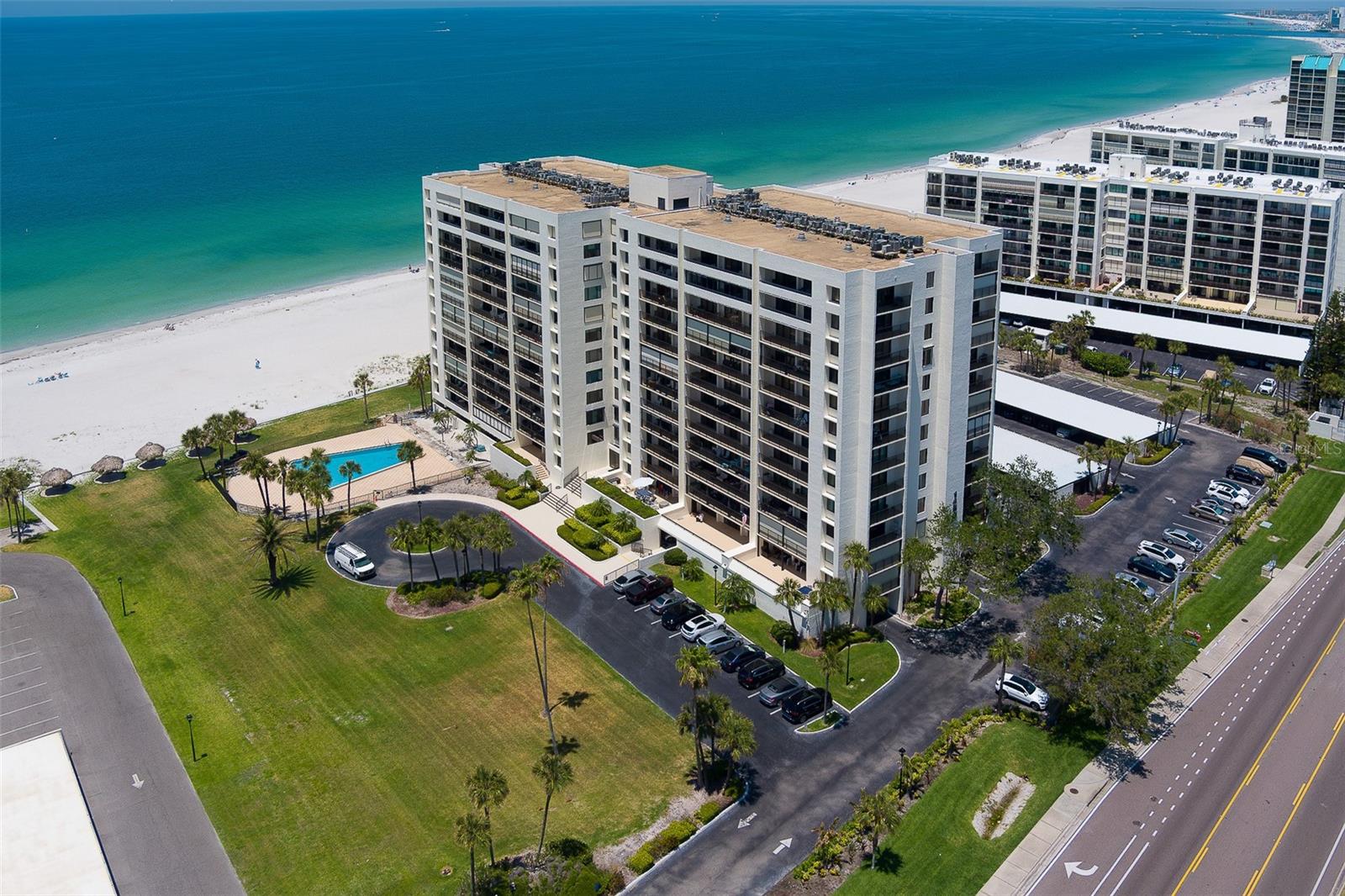 Welcome to coastal luxury living at its finest in this tastefully renovated residence! This stunning condo blends style and functionality, featuring a dream kitchen with a large island, granite countertops and backsplash, stainless steel appliances, solid wood cabinetry, and a custom dry bar complete with a wine refrigerator—perfect for entertaining. The open floor plan is complemented by luxury vinyl flooring throughout and new sliding doors that frame breathtaking panoramic views of the Gulf of America, the Intracoastal Waterway, and the sparkling night lights of Clearwater Beach. The spacious master suite offers a relaxing retreat with dual closets, an en suite bath featuring a tub/shower combo, and private access to the oversized balcony. The expansive balcony, accessible from the living room and both bedrooms, offers multiple seating areas and hurricane shutters for peace of mind. Additional features include an in-unit washer and dryer, new bedroom and bathroom doors, and a 2017 AC unit. This impeccably maintained community features a waterfront pool, tiki huts, a community room with kitchen, designated carport parking, and a ground-floor storage closet. With a well-managed association that has completed its milestone inspection and reserve study—with no assessments due—you can enjoy carefree living. Ideally located just south of vibrant Clearwater Beach and steps from the shops and restaurants of Sand Key, this is your opportunity to own a slice of paradise!