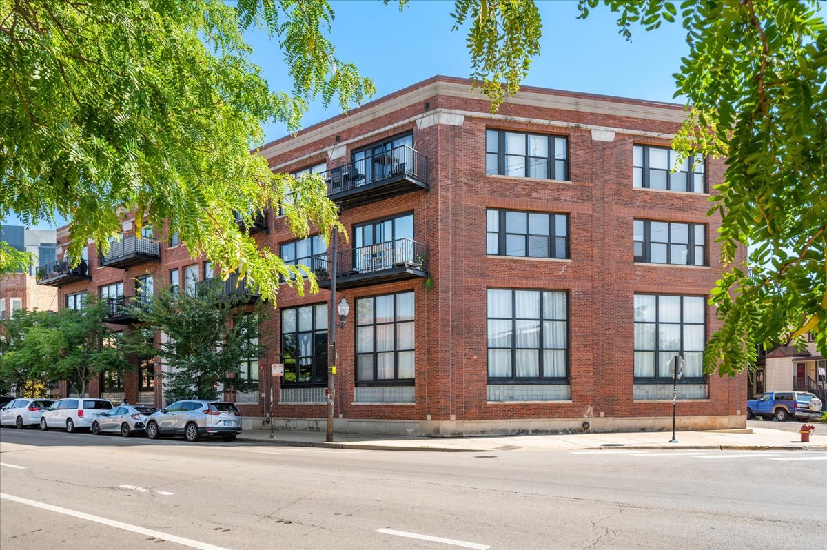Looking for a loft that checks every box and turns heads? Welcome to this gorgeous 2 bed / 2 bath corner loft in a boutique elevator building where history and modern style collide. Word on the street is that this former perfume factory once filled the neighborhood with fragrance - today, it's all about character and comfort. Step inside and be wowed by 16-foot timber ceilings, exposed brick, and oversized windows that flood the space with natural light. The kitchen makes a bold statement with its labradorite toned cabinetry, a playful homage to the Blue Line, injecting richness and personality into the home. White quartz counters, stainless steel appliances, and a spacious island perfect for entertaining round out the design, opening seamlessly to the dramatic living and dining area. Anchored by a fireplace and overlooking quiet St. George Street, it's the perfect backdrop for both entertaining and everyday living. Both bedrooms are generously sized, each offering two closets including a walk-in. The lofted primary suite spans the entire second floor with its own bath and flexible space for an in home office. And here's the kicker: this unit sits in the corner of the building with no neighbors on either side, giving you unmatched privacy in a vibrant community. Additional highlights include in-unit laundry, updated bathrooms, 2 heated attached garage parking spots (1 owned & 1 leased at $120 / month), and a location that puts you steps from the Blue Line, Logan Square and Bucktown's best restaurants, bars, shops, and the 606 Trail. This isn't just a home - it's a showstopper loft with a story as unique as its design.