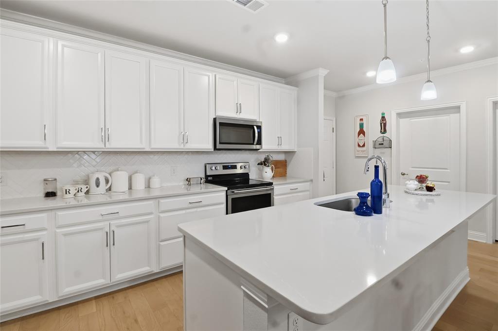 This 55+ Community is truly different! Inside this beautifully appointed, open-concept condo, you’ll find engineered wood floors throughout, quartz countertops, custom wood shutters in the bedrooms, a covered balcony with storage space, and stunning neutral finishes that will complement any style.

An oversized attached garage accompanies this unit—a rare find that provides convenience, security, and protection from the elements.

This 55+ community offers a resort-style pool, fitness center, pickleball court, grilling stations, party room, putting green, and firepit area.

If you’re looking for a lock-and-leave lifestyle with a great community, this is the perfect place! Washer, dryer, refrigerator, and three mounted TVs convey with the property. This home is truly move-in ready!