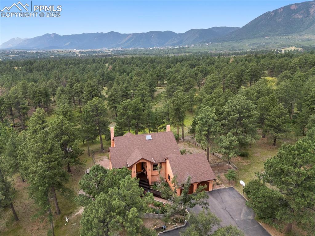 Imagine yourself in this stunning custom home on 2.5 park-like acres adjacent to Pike National Forest and surrounded by the peace and quiet that only this location can offer! This remarkable home has the ideal floorplan with both the primary retreat plus a second bedroom suite on the main level AND a study (or 3rd bedroom), dining room and spacious kitchen with inviting breakfast bay. The WOW begins at the front door with the gracious entry accented by freshly refinished hardwood flooring with handsome walnut inlay and vaulted ceilings that draw you through the home to the living room and gardener's delight sunroom (wired for hot tub). Large windows allow natural light and views of the gorgeous surroundings of terraced gardens and forest. The walkout lower level includes 2 large bedrooms with walk-in closets, game room, workshop and ample storage space. The over-sized 664 sf garage has plenty of room for sports equipment, bikes and tool storage. Eye-popping perennial gardens are a flower-lover's delight and are easy to maintain with sprinkler system and fenced to keep the deer away. You'll appreciate the NEW central a/c, furnace, hot water heater and roof, too. Need workshop space? The 22 x 12 shop has room for all your projects - or turn it into a 5th bedroom. Up to 2 horses allowed. Ideally located in award-winning School District 38, just 20 minutes north of Colorado Springs and 40 minutes to the Denver Tech Center. If you love the outdoors, you'll love the convenience of being able to hike, bike, or horseback ride the trails from the back of the property or kayak and paddleboard at nearby Monument Lake. This home is a dream come true! Please check additional documents for a complete list of the outstanding features of this home.