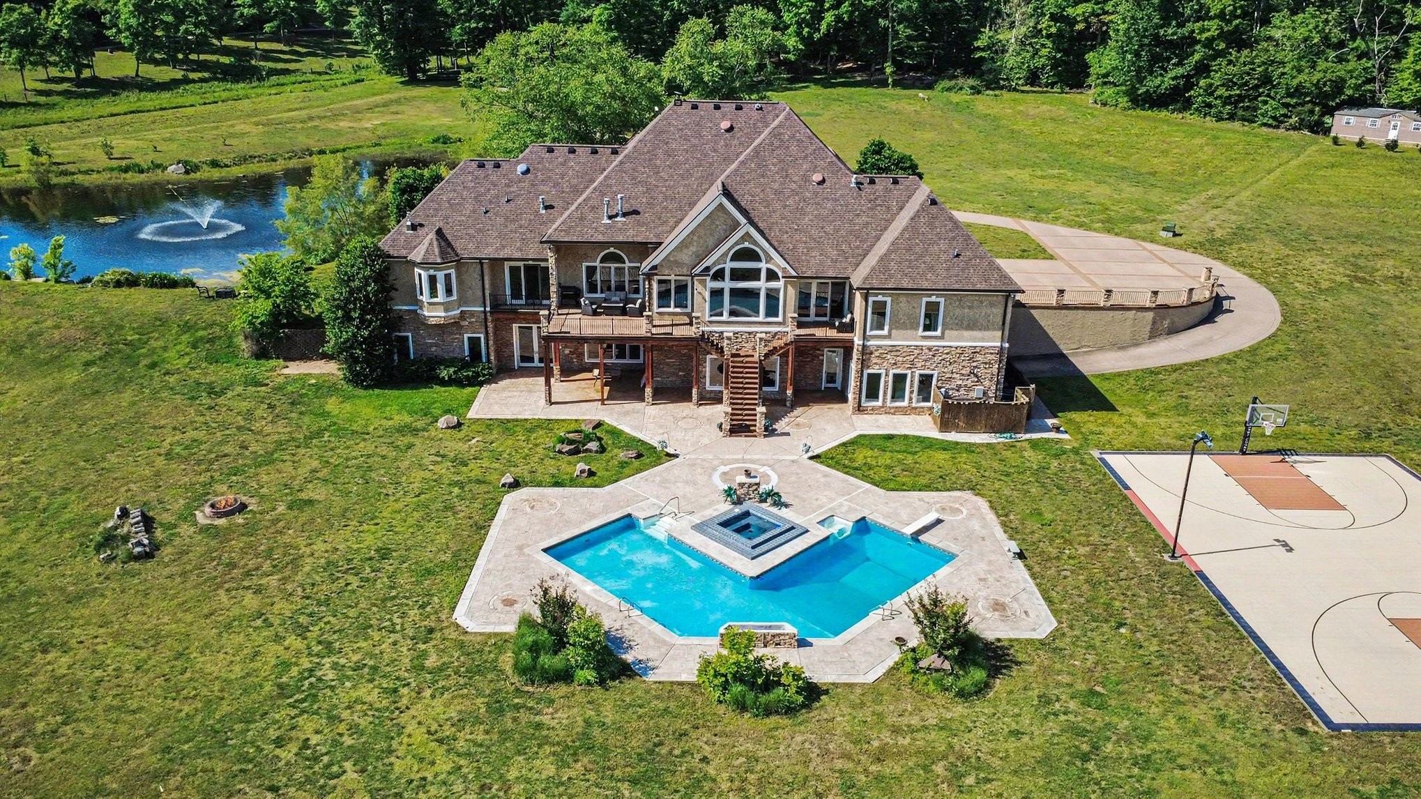 Assumable mortgage at 3.99% -- $2.375M assumed + $500K additional loan equals approx the same monthly payment as $2.2M loan at today's rates. Assuming 3.99% mortgage, buyers save $1.6M+ in interest over life of the loan — nearly $4,500 less per month than financing at today's rates. Rare 33-acre creekfront sanctuary surrounded on 3 sides by year-round Big Turnbull Creek, offering extraordinary Privacy, Recreation, & Tranquility 35 min from Nashville & min from I-40. Picturesque stocked pond with fountain welcomes guests - the 9,100 sq ft Craftsman residence emerges beyond. Capturing the surrounding landscape, the soaring 12–15 ft ceilings & expansive windows frame breathtaking views across the pool, grounds, creek & dramatic bluffs where bald eagles are seen soaring. The home showcases $2M+ in custom woodwork: inlaid hardwood floors, intricate millwork, solid wood doors, handcrafted trim around windows & doors, & detailed crown molding & baseboards. Kitchen features granite countertops, custom-height surfaces designed for comfort & entertaining, intricate wood cabinetry, & updated high-end appliances. 4 en-suite bedrooms are located on main level including a private primary retreat with fireplace, soaking tub, dual closets, impressive shower & balcony overlooking property. 2nd floor 1,000+ sqft bonus room flexible space. The finished walkout 4000+ sqft basement offers expansive entertaining space with double-sided fireplace, additional bedroom or fitness suite w/ full bath & cedar closet, plus a cedar-lined secure storage room. Outdoor living includes heated pool & spa w/ new automated equipment, lighted VersaCourt sport court for tennis, pickleball & basketball, firepit & gathering areas overlooking creek & bluffs. Amenities guest house w/ kitchenette & full bath, six-stall barn, 4 garage spaces including sep RV garage, Tesla charger, private well w/ filtration, broadband internet, tankless water heaters, 5 HVAC systems & insulated concrete form (ICF) construction.