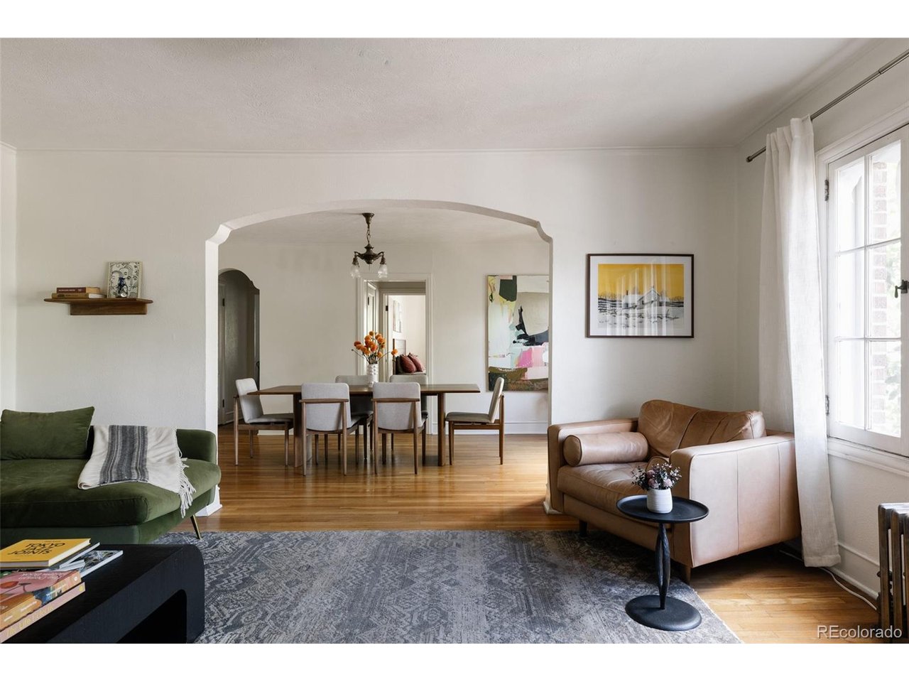 Welcome to Downing Manor, a little piece of old-world charm tucked into the heart of Capitol Hill. Built in 1928, this gracious corner condo feels like something you might stumble upon in a European neighborhood, complete with an unpainted brick exterior, original stained doors, beautiful windows, hardwood floors, built-ins, and arched doorways that quietly tell the story of another era. Set on the second floor, this is the only unit in the building offering more than 1,000 square feet. Step inside to a gracious living room filled with natural light, flowing effortlessly into a generous dining area; an entertainer's dream. North- and east-facing windows and tall ceilings give the home an airy, welcoming feel, whether you're enjoying a quiet morning or gathering friends for dinner. The kitchen was thoughtfully renovated in 2024, bringing modern convenience while preserving the home's character. Quartz countertops, custom cabinetry and hardware, stainless steel appliances, floating shelves, updated plumbing, a new window, and a water filtration system make this space as functional as it is charming. Storage is abundant, with large closets, floor-to-ceiling cabinetry in the kitchen hallway, and a reserved storage space in the basement. A reserved parking space behind the building is included, and there is potential to add in-unit laundry, with a licensed plumber's estimate available in the supplements. Outside your door, Capitol Hill unfolds around you, with coffee shops, restaurants, music venues, bars, and parks just steps away. New businesses continue to move in, adding to the neighborhood's vibrant energy while its longtime favorites remain. Cheesman Park and City Park are blocks away, with Potager, White Pie, Steuben's, City-O-City, Sprouts, Whole Foods, King Soopers, and Trader Joe's all nearby. A home with history, character, and the kind of location that makes city living feel effortless. ONE YEAR RATE BUY-DOWN AVAILABLE THROUGH PREFERRED LENDER.