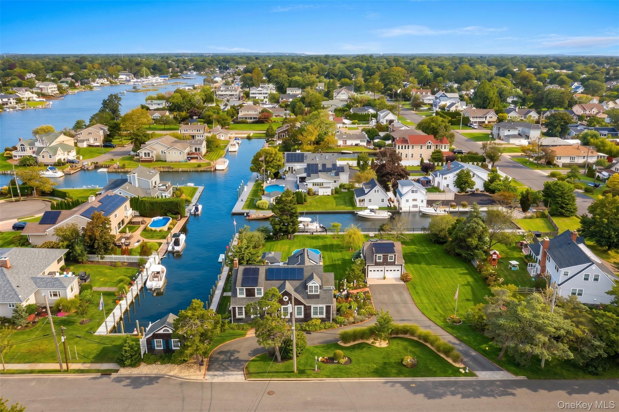 Discover the ultimate in resort-style living with this exceptional waterfront property! Nestled on nearly 3/4 acre (3 lots), this beautifully renovated 2,800 sq. ft. home offers sweeping water views from nearly every room.Enjoy 315 feet of Navy bulkhead equipped with water and electric, providing easy access to a 40-foot-wide canal. Unwind by the heated 15' x 30' pool, host gatherings on the expansive 700 sq. ft. composite deck, and fire up the BBQ by it's dedicated natural gas line. Relax in the dockside-cabana during summer afternoons and spend evenings gathered around the fire pit on the pergola patio. The 2.5-car detached garage features a loft, perfect for hobbies or additional storage.Inside, the oversized eat-in kitchen is a chef's dream with high-end appliances, a formal dining room, a welcoming family room and large living room with fireplace. Enhanced with 200-amp electrical service, LED lighting, solar panels (owned aprx $33 p/m electric bill) gas/hw tankless heating, central air conditioning (split units), and high-speed fiber-optic internet, this home seamlessly fuses classic charm with modern amenities. Don’t miss this rare opportunity!