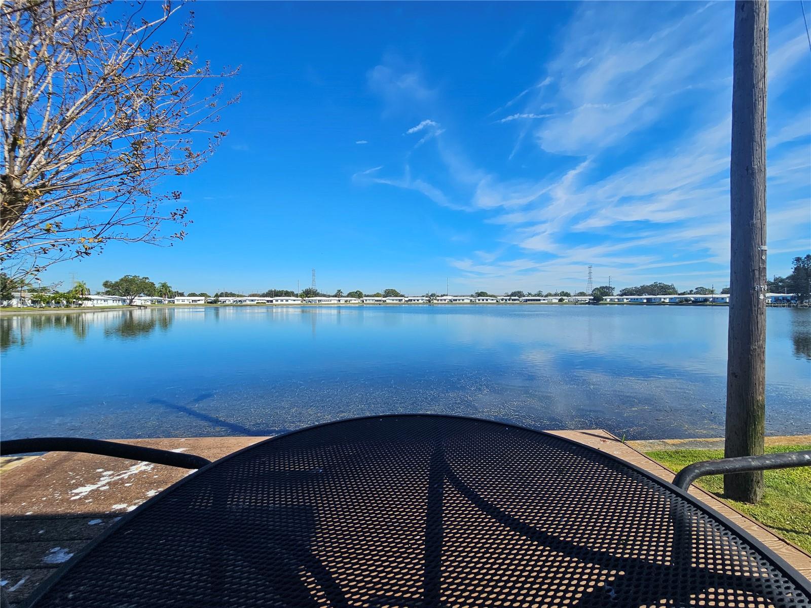 WATERFRONT LIVING IN STYLE… ENJOY YOUR NEW HOME IN THIS ACTIVE 55+ COMMUNITY JUST MINUTES FROM ST PETERSBURG & CLEARWATER!!  Recently remodeled, you will love the panoramic waterfront views and gentle sunrises every day from the comfort of your kitchen, dining area, family room and coffee bar — a serene backdrop that sets the stage for peaceful mornings and relaxing afternoons. The setting is truly unique, offering a sense of escape and connection with nature right outside your door.  This beautifully updated home features two spacious bedrooms and two modern bathrooms. Extensive renovations over the past three years make this residence shine including an updated kitchen with newer appliances, luxury vinyl flooring throughout and fully renovated bathrooms including widened doorways in the primary bathroom to allow easy accessibility.  All doors and hardware have been replaced, five new ceiling fans bring comfort and beauty, and every window is adorned with custom blinds for privacy and style. The exterior includes a new awning, new gutters and soffits, and custom concrete curbs that frame lush flower beds and thoughtful landscaping. A brand-new tile roof, courtesy of the HOA, delivers lasting durability and protection and the new HVAC system and enhanced safety features – among other finishes – give additional peace of mind.   Additionally, if you are looking for an active, centrally located retirement community where you can easily make friends and visit family, “The Mainlands” is for you!  Participate in community breakfasts, bingo, dances, and more at the vibrant clubhouse and pool just blocks away. Golf enthusiasts will appreciate the nearby public course, and pet owners can enjoy strolls with their companions. Personal golf carts are welcomed, making it easy to visit local shopping, Freedom Lake Park, and explore everything the neighborhood offers.  Centrally located, you’re just minutes from Tampa and St. Pete/Clearwater airports, superb dining, shopping, and the breathtaking Gulf Coast beaches. The monthly maintenance fee covers a comprehensive range of services, from roof and exterior painting, water, sewer, trash, basic cable and internet, to full lawn care and clubhouse/pool upkeep. This all-inclusive approach means you can spend more time embracing the lifestyle you love so CALL TO SCHEDULE YOUR SHOWING AND MAKE THIS YOUR NEW HOME TODAY!!
