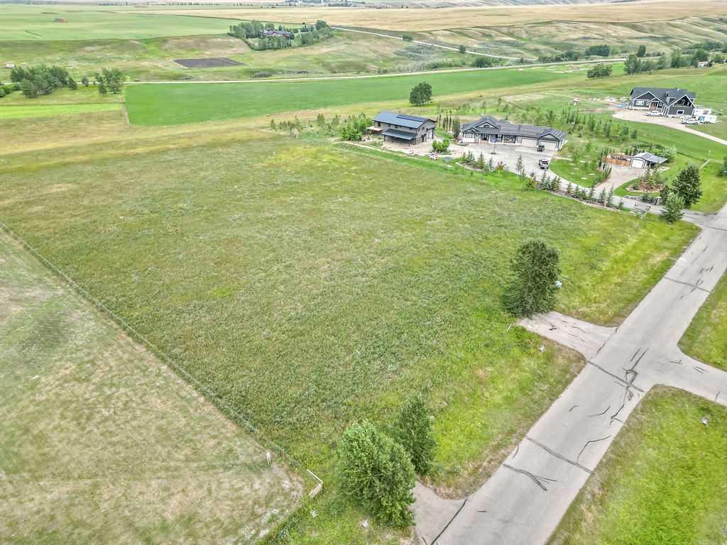 STOP! You have found the ideal spot to build your dream home on a peaceful 3.1 acres located close to Calgary, Okotoks, Heritage Heights School, St. Francis of Assisi Schools, and Scott Seaman Arena. With no time commitment to start your build, this is a great opportunity to secure an amazing location with paved roads and utilities right up to the fenced property line, a drilled well, and backing onto a tranquil valley.