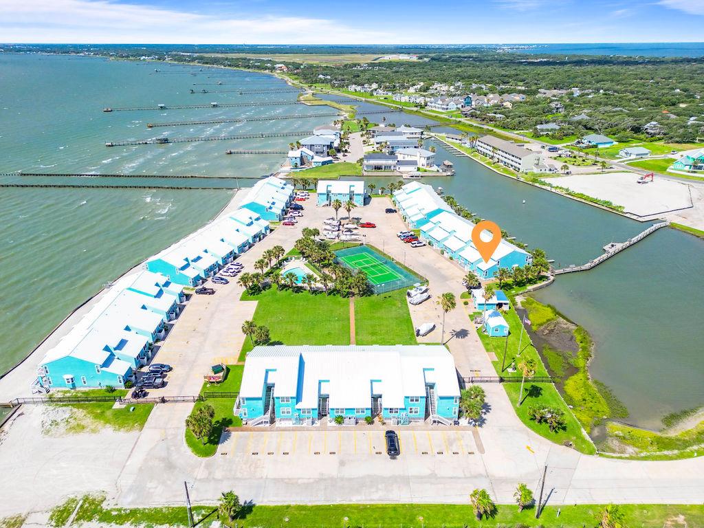 Waterfront living made easy at Kontiki Condos! This beautifully maintained and fully furnished condo offers the ultimate coastal lifestyle with direct Aransas Bay access and your very own private boat slip just steps from your door. Wake up to sparkling water views and enjoy breezy evenings from your private balcony. Inside, the open-concept living space is tastefully appointed with coastal dcor, updated finishes, and everything you need to move right in—just bring your suitcase! Whether you're looking for a turnkey vacation home, short-term rental investment, or full-time waterfront retreat, this property delivers. Enjoy access to the community pool, lighted fishing pier, and a prime location just minutes from Rockport Beach, downtown shops, and local dining.  Don't miss this rare opportunity to own a piece of paradise on the Texas coast!