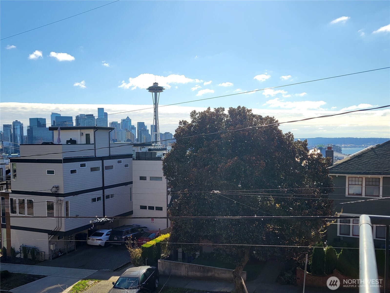 116 Aloha offers a rare kind of Queen Anne condo living: a three-level home with real separation, two oversized gated parking spaces and the feel of a private city residence. The reverse floorplan puts the main living level on top, where kitchen, dining and living spaces open together with hardwood floors, gas fireplace, breakfast nook and outlooks that give the home light and lift above the street along with a downtown, Elliott Bay and space needle view.    The layout works because each level has a clear job. The top floor is for gathering, cooking, working from the table and ending the day by the fire. The middle level gives the primary suite its own quiet position, separated from the social spaces above and guest/flex rooms below. The garden-level entry adds an en-suite bedroom and a flexible second room for office, guests, media, fitness or storage. A private patio extends the level outside.    Private outdoor space, in-unit laundry and secure building access support the daily pieces, while two oversized gated parking spaces give the home a practical advantage that is hard to overstate in Queen Anne. This is not a standard flat condo. It is a layered city home for someone who wants more privacy, more function and more room to live without leaving the neighborhood.    Set on Queen Anne, close to Lake Union, the Seattle Center, KEXP, Climate Pledge, blocks to Kerry park, coffee, transit and downtown. A city home with separation, parking and a plan that lives well.