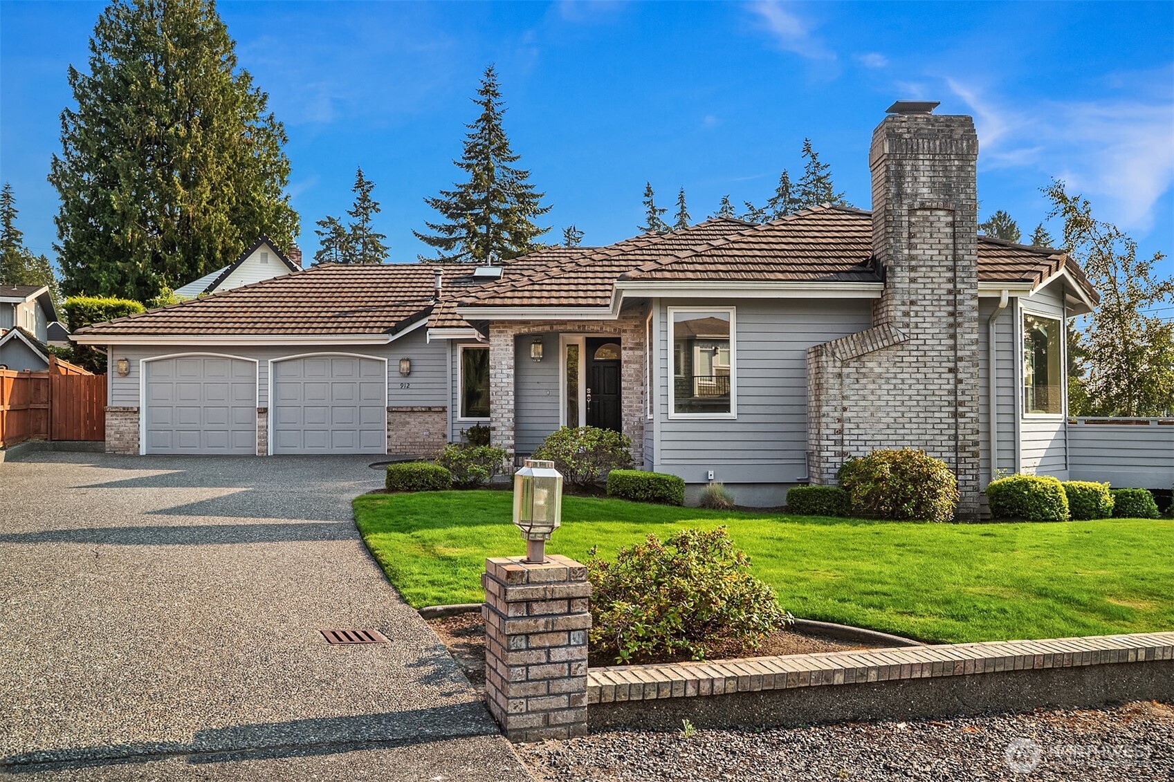 Beautifully positioned in the Edmonds Bowl, this light-filled rambler offers refined single-level living with a thoughtful balance of space, warmth, and connection to its surroundings. Sound, mountain, and territorial views add a distinctive sense of place, while vaulted ceilings, skylights, and expansive windows fill the interior with natural light. The generous living room is anchored by a gas fireplace, with rich hardwood floors extending through the dining and kitchen areas to create an inviting flow between spaces. The bright kitchen features crisp white cabinetry, expansive counters, stainless appliances, abundant storage, and an adjoining eating area, while a separate family room and dedicated office provide added flexibility. The thoughtfully designed single-level floor plan features three bedrooms and two full baths, including a spacious primary suite with a five-piece bath, dual sinks, built-ins, walk-in closet, and direct access to the deck. A dedicated laundry room with utility sink and extensive storage cabinetry adds everyday functionality. Outside, an expansive deck with built-in seating creates a natural extension of the home—ideal for dining, entertaining, or simply taking in the view—while the level, fully fenced yard adds usable outdoor space. An attached two-car garage is complemented by an extended driveway with additional parking space.