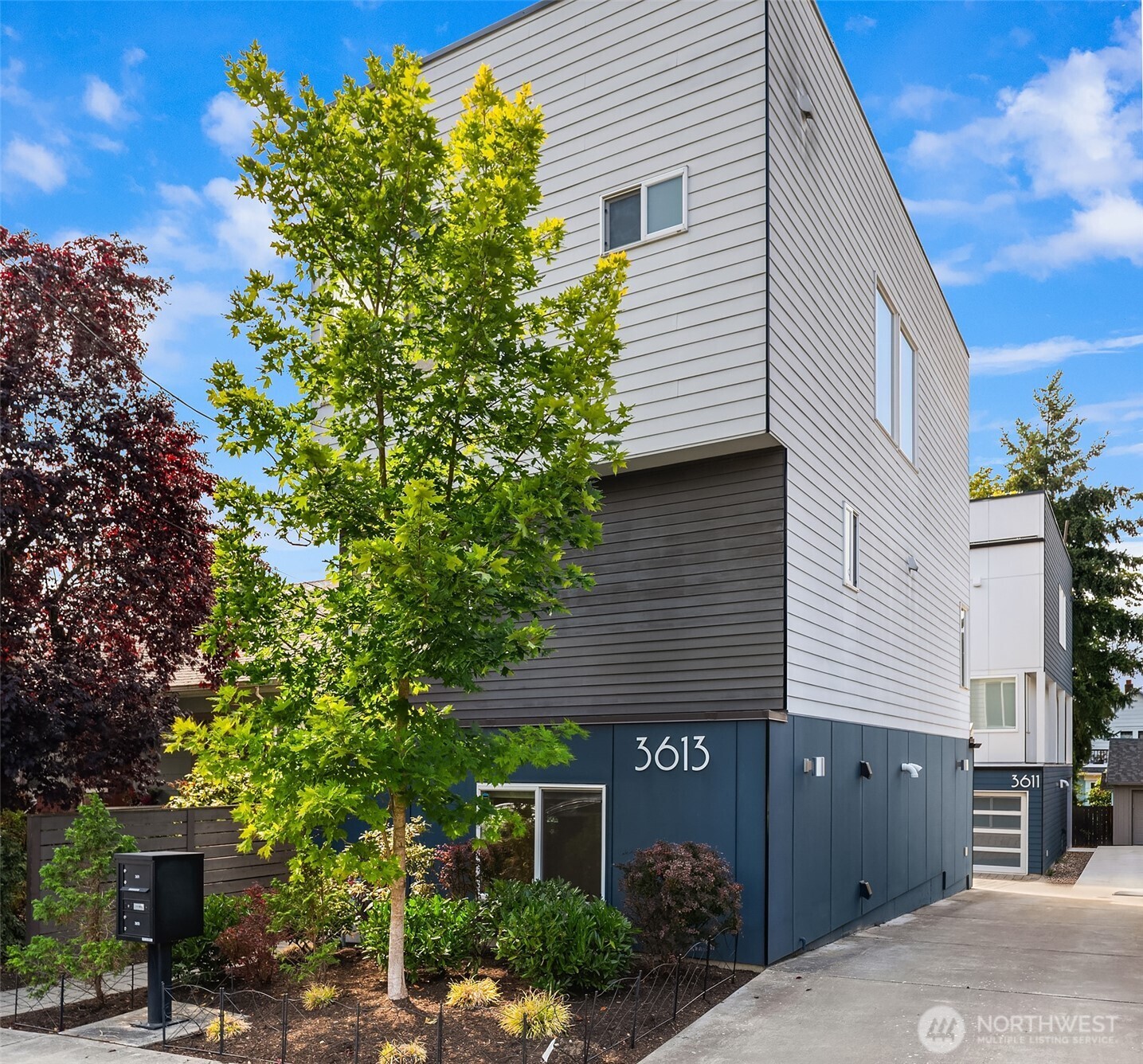 Detached, single family, and built by Steele Homes, this home pairs an oversized garage with panoramic Lake Union views, a combination that rarely surfaces in South Wallingford. Nearly everything worth reaching is within walking distance too. Cantinetta anchors the corner, with Gas Works Park, the Burke Gilman Trail, and a run of neighborhood cafes and breweries only blocks away, and Green Lake is a quick jaunt before dinner. Step inside and the sense of space is immediate, wide rooms, a private entry, room to spread out on every level. Hardwoods, painted millwork and hand finished metal railings are those extra touches you don't see often. Slab quartz with a professional grade appliance package defines the kitchen, open to dining and living. The primary suite offers its own bath and walk in. Downstairs, a third bedroom or office shares the level with the laundry room and attached garage, adding flexibility and genuine storage. New carpet grounds all the bedrooms. A private rooftop terrace crowns the home, framing Lake Union, the Seattle skyline, and the Space Needle beyond, suited equally to a quiet morning coffee or an evening spent entertaining.