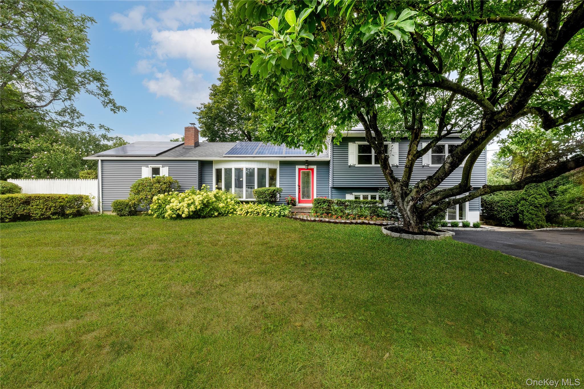 Located in the highly desirable Torbank neighborhood, this beautifully maintained split-level home offers 4 bedrooms, 3.5  baths, and a perfect balance of comfort, thoughtful updates, and eco-conscious living. Hardwood floors run throughout the home, enhancing its warmth and timeless appeal. A serene main-level bedroom suite includes a walk in closet, Ensuite full bath with shower, and direct access to a fully fenced patio and garden, ideal for quiet relaxation. The updated kitchen features custom cherry cabinetry, granite countertops, stainless steel appliances, pantry for added storage. Natural light pours into the spacious living room through a large bow window, while a raised hearth brick fireplace with a wood-burning stove creates an inviting atmosphere. Solar panels offer long-term energy savings and efficiency, supporting a more sustainable lifestyle. The three full bathrooms ensure convenience for all residents and guests. A generous rear deck overlooks lush, mature perennial gardens, providing a peaceful and picturesque setting perfect for entertaining or unwinding. Convenient to shops, highways and metro-north commute to New York City.