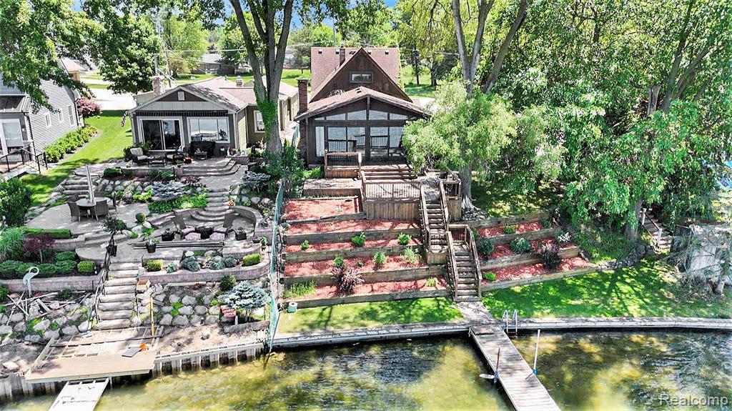 This Tudor-style waterfront retreat on all-sports Lake Fenton offers timeless charm and serene lakefront living with 45 feet of frontage on an expansive double lot. A graceful wrap-around driveway sets the tone, welcoming you to a home that blends character with comfort. Inside, you’ll find 3 nice-sized bedrooms and 2 thoughtfully designed baths, including an updated main bathroom with modern finishes. Newer windows frame breathtaking lake views and invite natural light to pour into every room, creating a warm and airy ambiance throughout. Step outside to enjoy your morning coffee or host unforgettable gatherings on the lakeside deck. The 2022 dock is ready for boats, paddle boards, or soaking in sunset views. Whether you’re embracing summer on the water or enjoying the peaceful setting year-round, this home is made for lake life. With charming architectural details, great outdoor space, and on desirable Lake Fenton, this is your chance to own a piece of Fenton's popular waterfront.