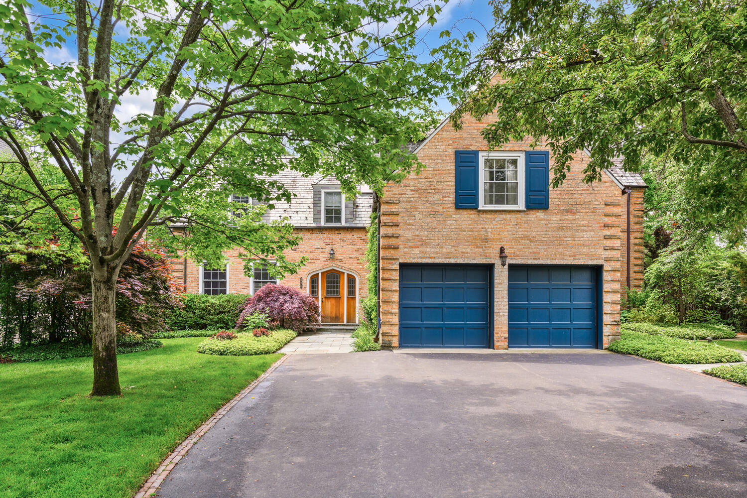 Experience timeless elegance and modern luxury in this stately 6-bedroom, 5 and 1/2 bathroom estate nestled on an oversized, professionally landscaped lot in the heart of Glencoe. Thoughtfully designed for everyday comfort and effortless entertaining, this exceptional residence blends grand scale with refined detail. At its core, a chef's kitchen impresses with premium stainless-steel appliances, custom cabinetry, two oversized islands, a walk-in pantry, and a spacious breakfast area that opens to a bluestone patio and the private, fenced backyard. The soaring family room features a vaulted beamed ceiling with inset lighting, a gas-start wood-burning fireplace, custom media center, and expansive floor-to-ceiling windows-including dual sliding glass doors-creating a seamless indoor-outdoor living experience. A formal dining room sets the stage for memorable gatherings, while the elegant living room offers arched built-in bookcases and a second fireplace. The main level also includes a private office, mudroom with laundry, multiple guest closets, and a powder room. Upstairs, find four generously sized bedrooms and four full baths, including a sunlit primary suite with built-ins, a jetted soaking tub, and a walk-in steam shower. A second vaulted en-suite bedroom offers alternate primary potential. The third level features a second office or flexible space and a fifth bedroom, currently used as a fitness room. The finished lower level includes a sixth bedroom with a renovated en-suite bath, a large recreation/playroom, and abundant storage. Outside, enjoy multiple bluestone patios, mature trees, and manicured grounds ideal for relaxing or entertaining. A heated two-car attached garage and a premier location-close to town, train, schools, parks, the lake, and several golf courses-complete this rare and remarkable offering in one of the North Shore's most desirable communities.