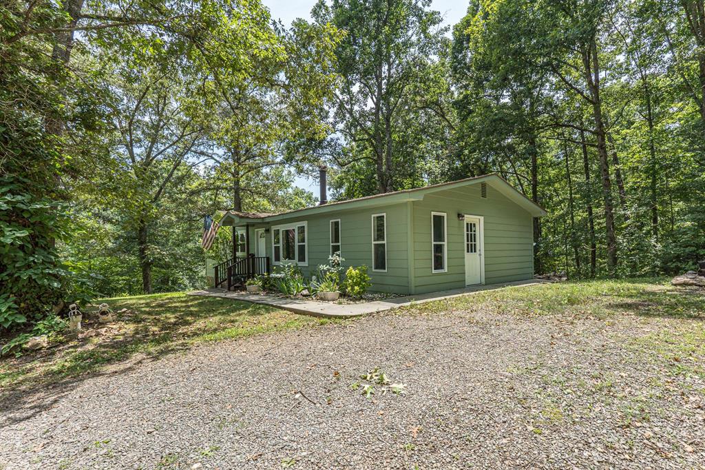 Welcome Home to this beautifully maintained 3-bedroom, 1.5 bathroom home offering just over 1,200 square feet of comfortable living space, ideally situated just minutes from Murphy, Blue Ridge, and Blairsville. Enjoy easy access to outdoor adventures like river rafting, hiking, and mountain exploring, while still being close to charming small towns with dining, shopping, and more. Inside, you have a spacious living area with a wood burning stove and beautiful wood floors and a den with a half bath and laundry area. The kitchen is equipped with stainless steel appliances, ample cabinet and counter space, making meal prep a breeze. Each of the three bedrooms offers plenty of room for family, guests, or a home office setup.m with access to the main bath in the hallway. High-speed fiber optic internet provides fast, reliable connectivity for work or play. Step outside to a welcoming outdoor porch—perfect for morning coffee or evening gatherings—and enjoy the usable almost 3 acre yard space for gardening, pets, or simply soaking in the peaceful surroundings. There is also an old well on the back of the property. Crawlspace storage gives you room to tuck away seasonal items, tools, or gear for your outdoor adventures. You will find that this home combines comfort, convenience, and outdoor charm in one inviting package.