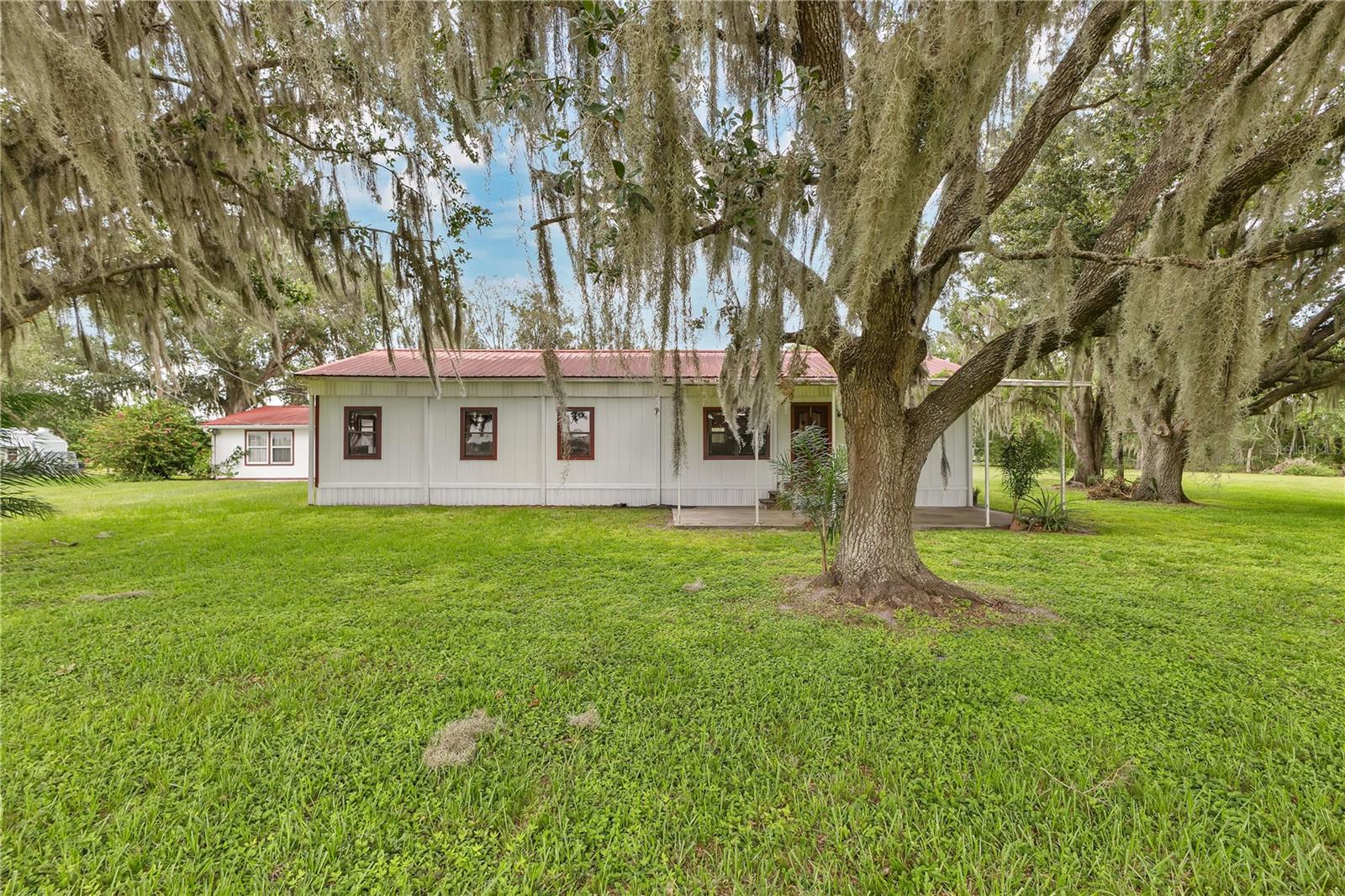 Peaceful Country Living on 2+ Acres in Kenansville, FL! Welcome to your private slice of Old Florida! This charming 3-bedroom, 2-bath home sits on over 2 acres of cleared land and offers the perfect blend of space, comfort, and versatility. Featuring a detached mother-in-law suite, it's ideal for multigenerational living, guests, or rental income. Need extra room for your toys or tools? You’ll love the small carport/barn, perfect for boat storage or equipment. Enjoy wide-open skies, fresh air, and the peacefulness of rural life while still being within reach of town conveniences. Whether you're looking for a homestead, weekend retreat, or a place with room to grow—this property checks all the boxes.