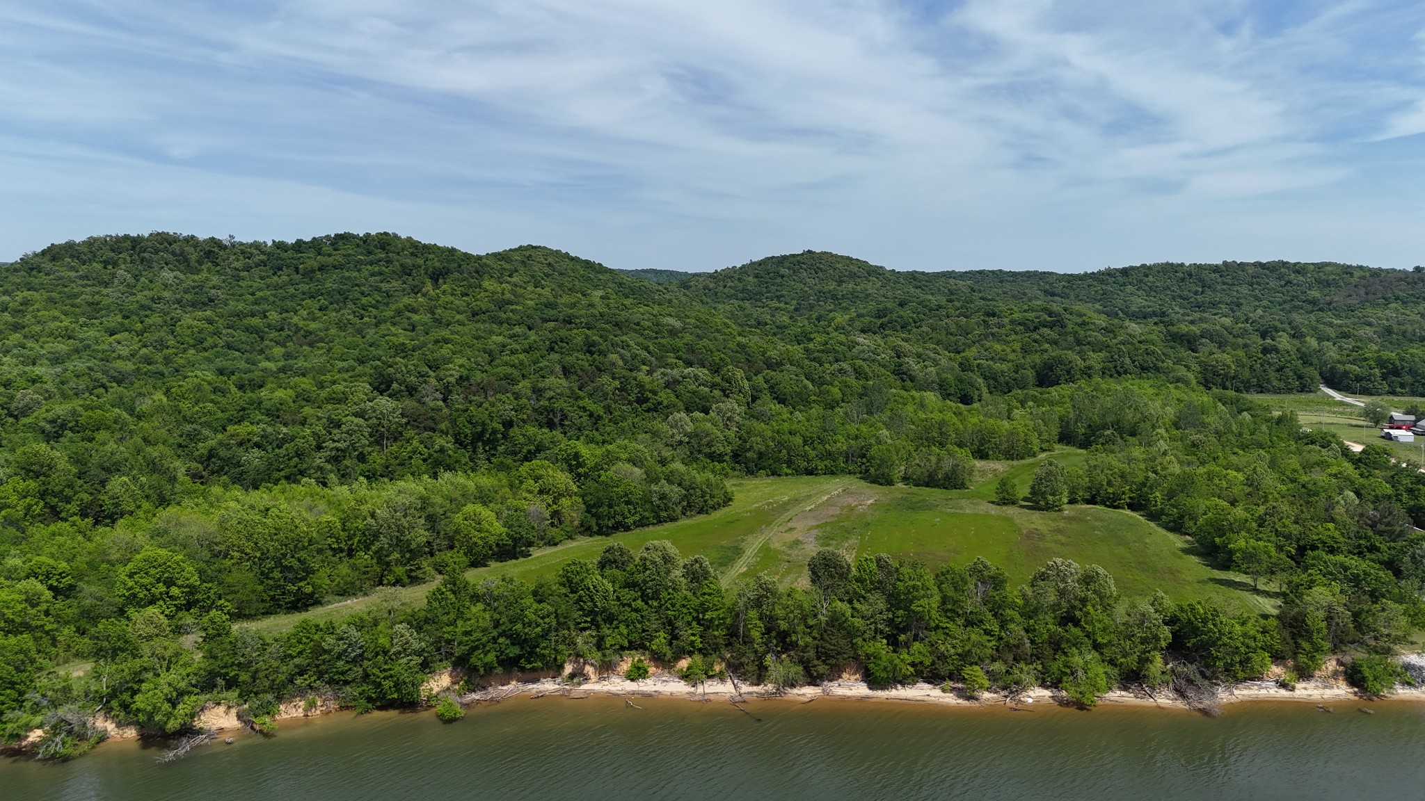 Introducing Fugate Farms—a stunning 160+/- Acre property with roughly 1,100+/- feet of Tennessee River frontage. From 20+/- Acres of established food plots and fields, trail system throughout, 140+/- Acres of mature hardwood timber, bluff views, springs, creek, slough from the river, and a 2-bed, 1-bath cabin and shed, this property has it all. Exceptional hunting opportunities such as deer, turkey and a history of successful dove fields. The river and slough provide waterfowl opportunity along with fishing and boating. Cabin is setup with water, electric, & septic (1-bed permit) with fiber available at the road (ML Connect). Property is situated between Eagles Bend and Kellys Landing river developments providing potential for this property to be used for riverfront development and docks on the water. Call today to schedule a private showing! Buyer/Buyer’s Agent to verify all details.