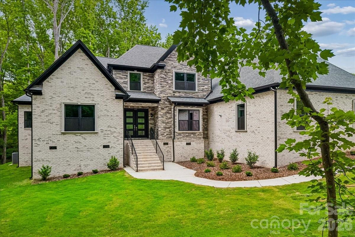 Stunning custom-built full brick home on a private 1.2-acre lot in an established Waxhaw community with sought-after Marvin schools. This thoughtfully designed residence embodies refined luxury and effortless entertaining, offering 4 bedrooms, a private office, a spacious bonus room, 6 full baths, and an extra half bath. The open floor plan features coffered ceilings, extensive trim work, and no carpet throughout. At the heart of the home, the chef's kitchen is both functional and impressive - anchored by an oversized island, abundant counter space, quartz countertops, gray shaker cabinetry, a bold tile backsplash, double wall ovens, and a gas cooktop — all open to the breakfast area and family room with a sleek electric fireplace that brings both modern style and cozy ambiance. The main level also includes a formal dining room, private office, and a generous utility room with laundry. The main-level primary suite serves as a true private retreat with cove ceiling lighting, an electric fireplace, a custom closet, and a spa-inspired bath with designer tile finishes. Every bedroom features its own custom closet, offering thoughtful storage throughout. Upstairs, the expansive bonus room with a wet bar offers endless flexibility - media room, guest suite, or entertainment space. Additional highlights include a side-load 3-car garage, tankless water heater, and beautifully appointed bathrooms with stylish navy cabinetry throughout. Enjoy all of this with HOA dues of just $157 annually - exceptional value for the lifestyle and location. Located just minutes from Blakeney, Waverly, and all the dining, shopping, and conveniences the area has to offer. The septic permit is for 4 bedrooms.