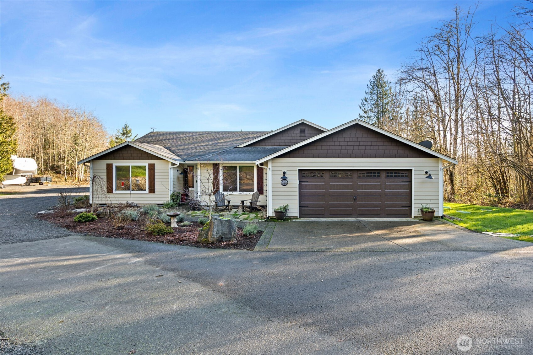 Welcome to the highly sought-after Glacier Peak Estates! This beautiful rambler sits on five private, serene acres, offering space, comfort, and stunning natural surroundings. Designed for easy living and entertaining, the home features 3 bedrooms, 2 bathrooms, plus a versatile office/den. The open layout is filled with natural light and showcases a spacious kitchen with LG appliances and an island, flowing seamlessly into the dining and living areas. Vaulted ceilings, rich flooring, and a wood-burning fireplace create a warm, inviting atmosphere. The primary suite is a true retreat, with a stone soaking tub, quartz walk-in shower, and quartz countertops. A generous walk-in closet and private deck access provide the perfect spot to enjoy majestic sunrises and sunsets. Outside, the property shines in spring with vibrant landscaping, flowering bushes, and colorful blooms—you need to see it! RV parking, multiple outbuildings, and a designated building pad that offers a great starting point for a future shop.