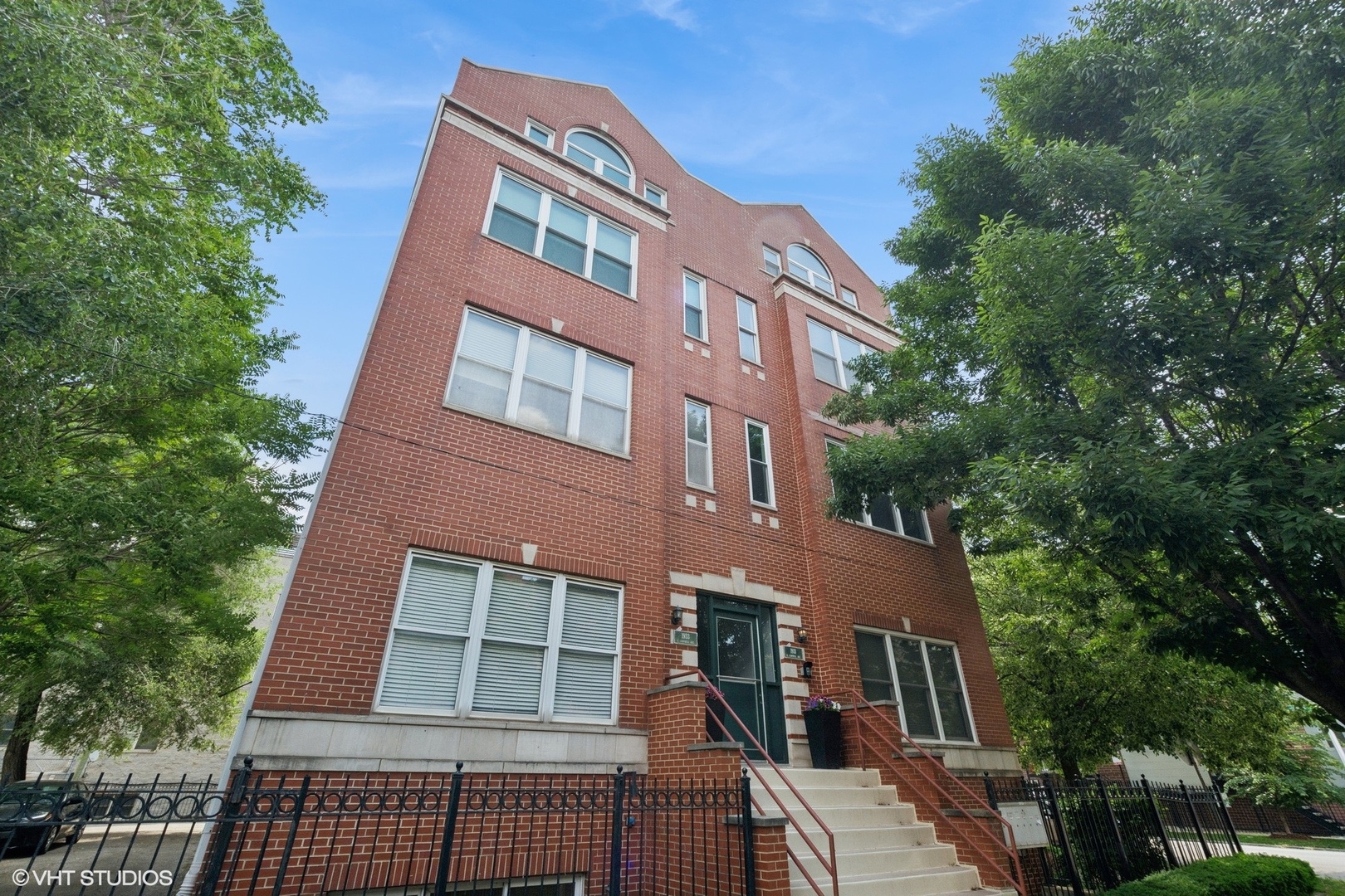 Bathed in natural light and surrounded by tree-lined views, this extra-wide corner 2 bed, 2 bath home sits in a prime Logan Square location. The spacious open floor plan offers generous living and dining areas, a large kitchen, and a flexible nook-perfect for a home office, reading lounge, or expanded seating area. Southern-facing windows overlook a lush neighborhood street, while inside, custom built-in bookshelves, a cozy gas fireplace, hardwood floors, and tall ceilings add warmth and character. The kitchen is outfitted with tall wood cabinetry for excellent storage, granite countertops with a breakfast bar, and stainless steel appliances. The bright and airy primary suite features an organized double closet, private balcony, and ensuite bath. The second bedroom is also well-sized with built-out closets for added storage. Recent updates include: water heater (2023), washer/dryer (2023), refrigerator (2023), A/C (2021), and furnace (2014). One gated parking space and additional storage included. Unbeatable location-just minutes to the Blue Line, multiple bus routes, the 606 Trail, and quick expressway access. Enjoy easy walks to Logan Square, Bucktown, and Wicker Park's top-rated restaurants, bars, cafes, and boutiques. Pet- and investor-friendly building makes this home a smart choice for homeowners and landlords alike.